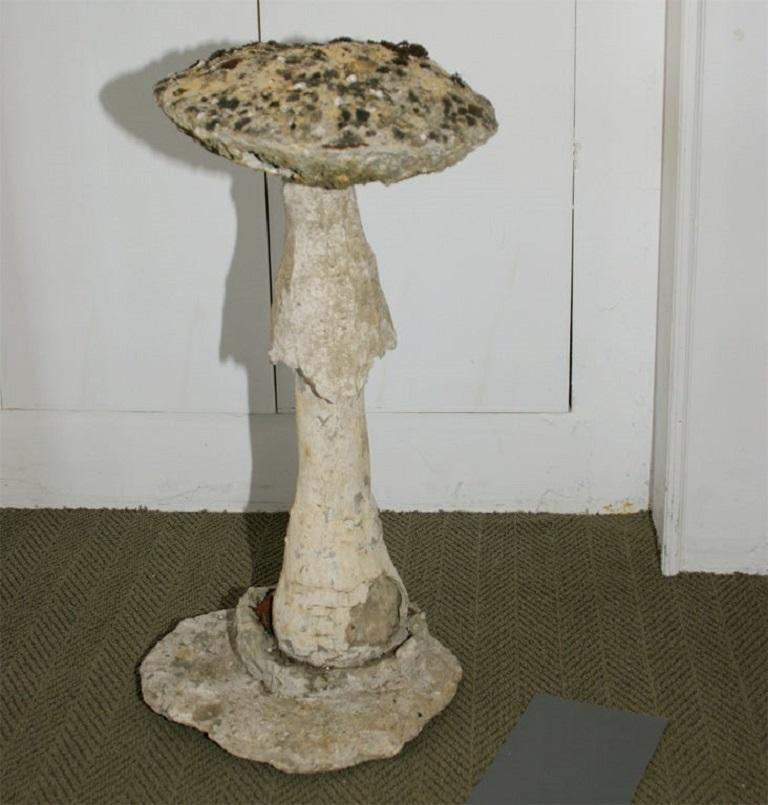 Naturalistic stone mushroom on free-form base, moss patina.