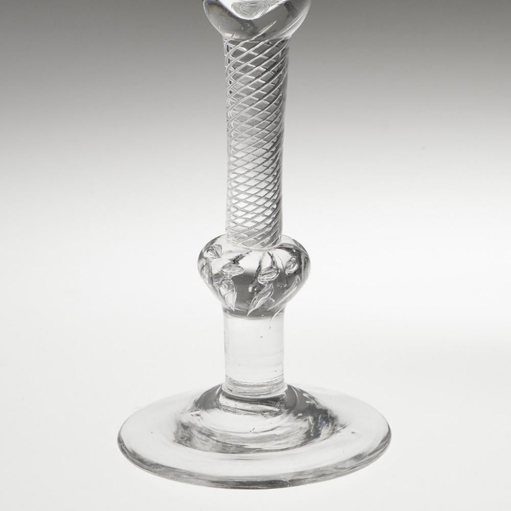 Heading : Composite stem Georgian wine glass
Period : George II - c1750
Origin : England
Colour : Clear
Bowl : Bell
Stem : Multi spiral air twist, beaded inverted baluster knop, short plain stem section
Foot : Conical
Pontil : Snapped
Glass Type :