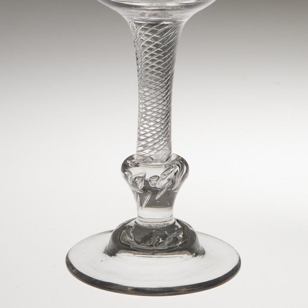 Heading : Georgian composite stem wine glass
Period : George II - c1740-1750
Origin : England
Colour : Clear
Bowl : Tulip
Stem : Multi spiral air twist above an inverted baluster knop containing an air beaded rosette.
Foot : Domed
Pontil :