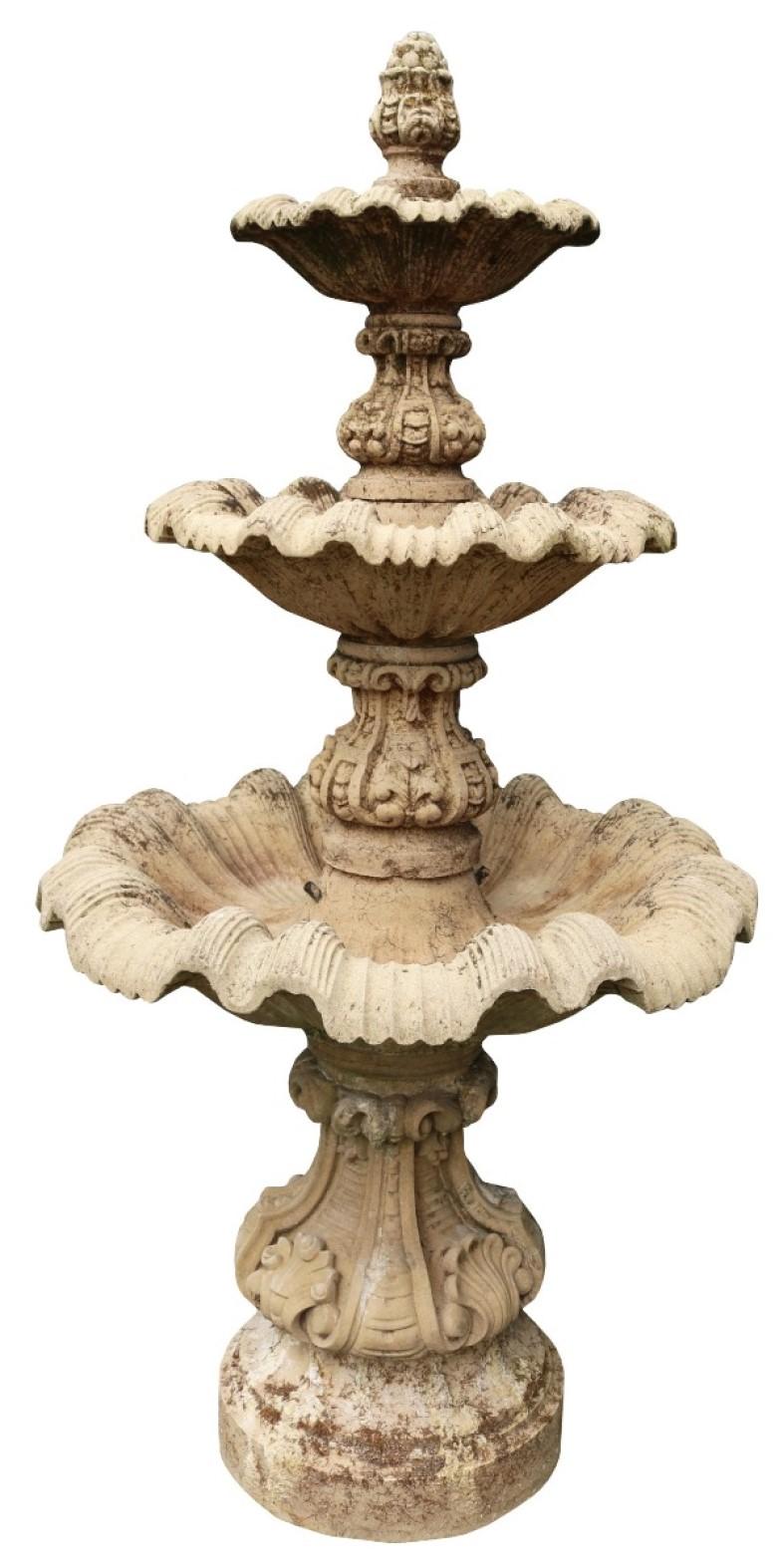 A weathered three tier composition stone garden fountain.