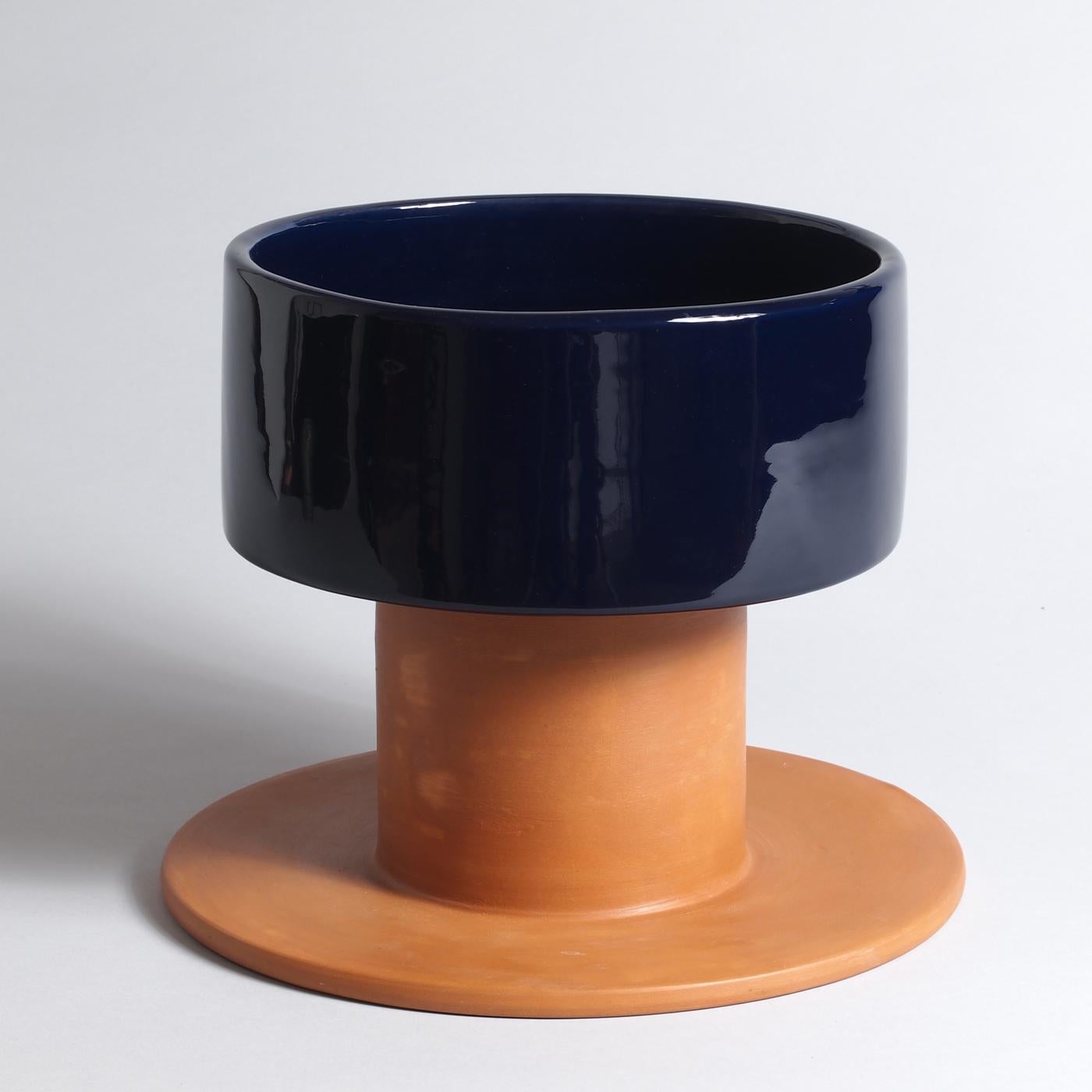 Two elements recalling medieval goblets are interlocked in this singular sculpture, creating a symmetrical body with alternating midnight blue-glazed majolica and bisque terracotta pieces. Once the two elements are detached, the design discloses its