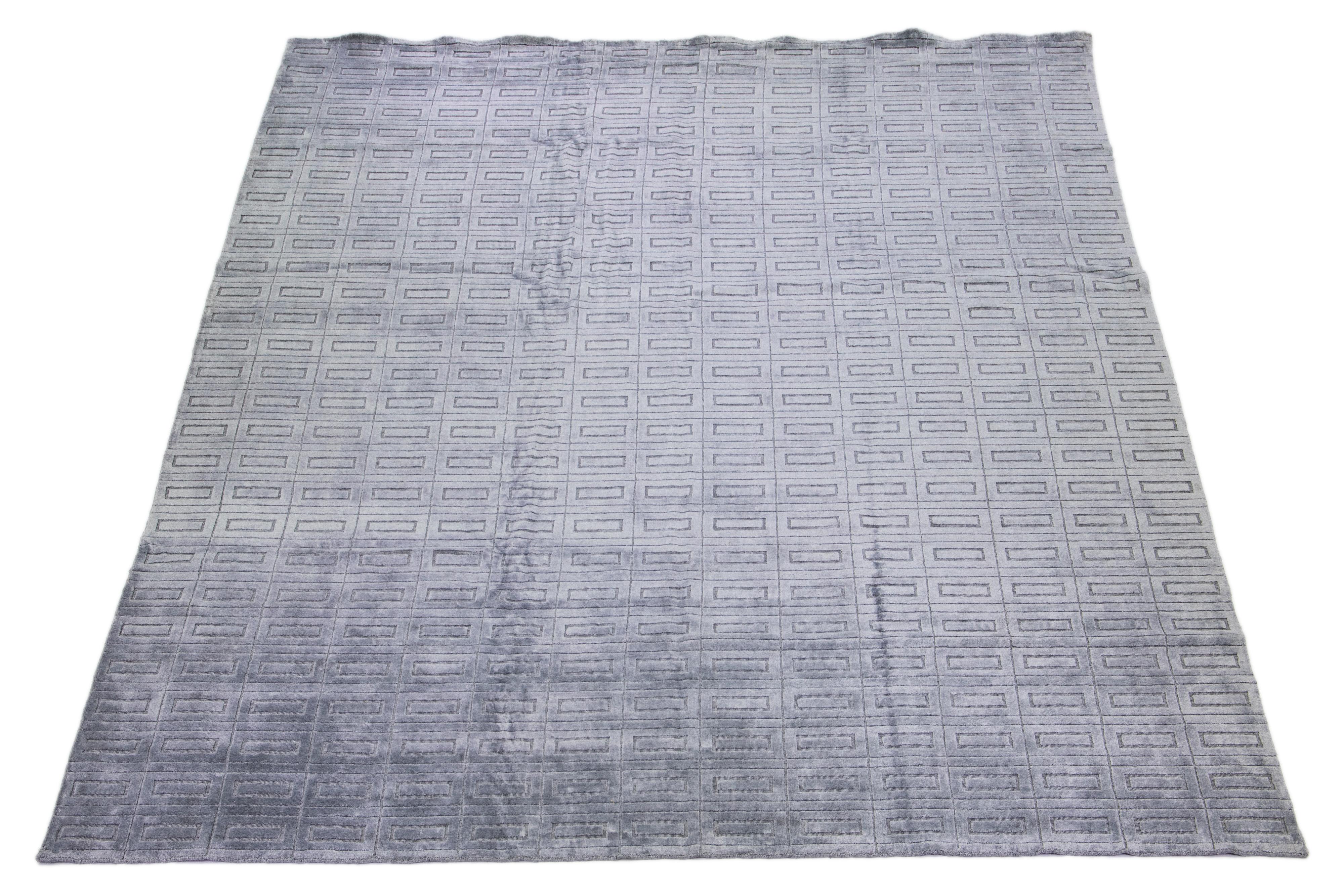 Schöner moderner Ikat-Teppich aus handgeknüpfter Wolle mit einem grau-silbernen Farbfeld. Dieses Stück hat ein wunderschönes geometrisches All-Over-Muster.

Dieser Teppich misst: 12'1