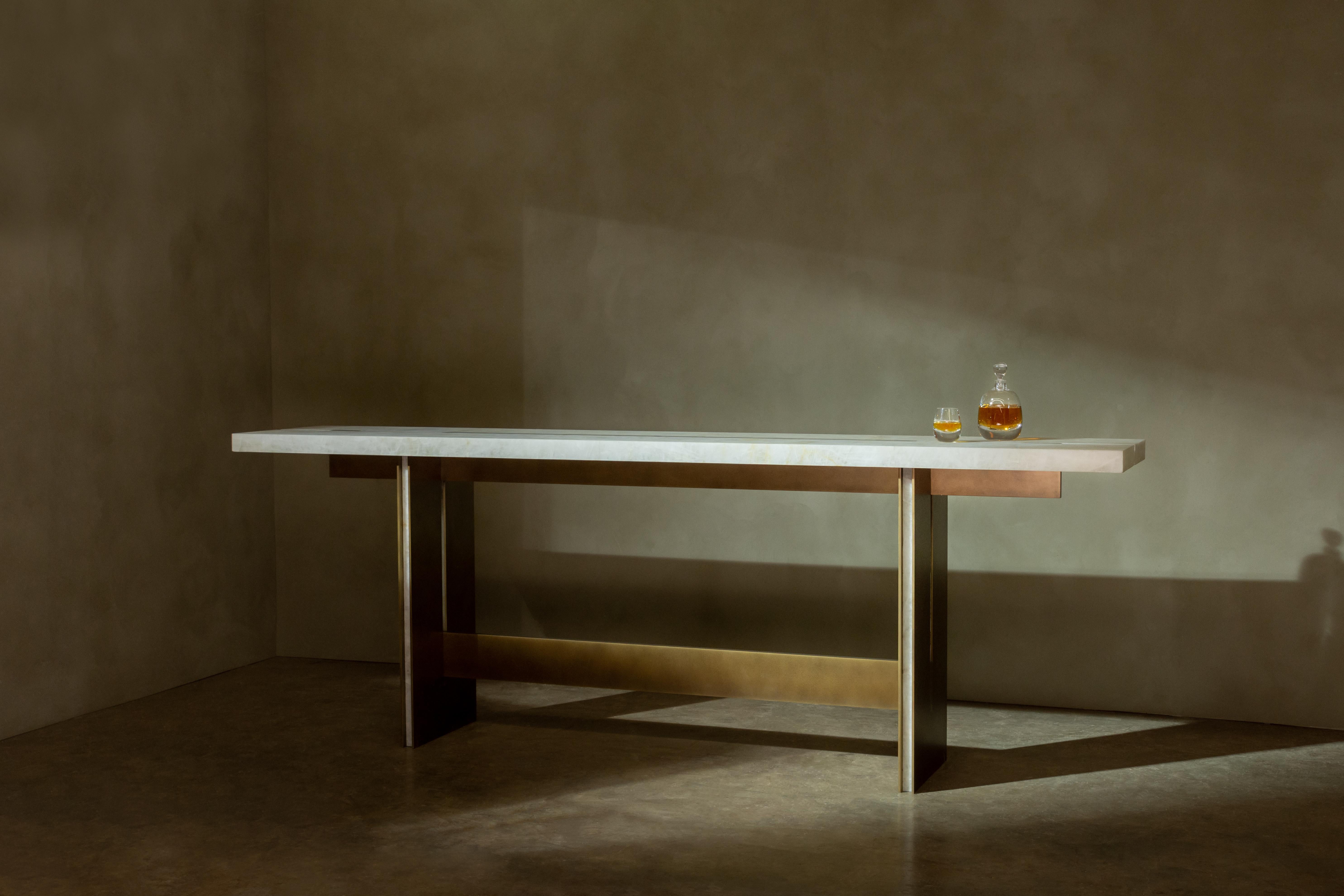 Barhoher Tisch, der aus sich kreuzenden Stein- und Metallelementen zusammengesetzt ist, die klare, geometrische Kompositionen bilden. Die Details der Stein- und Metalleinlagen sowie die präzisen Ausschnitte veredeln das minimalistische Design.