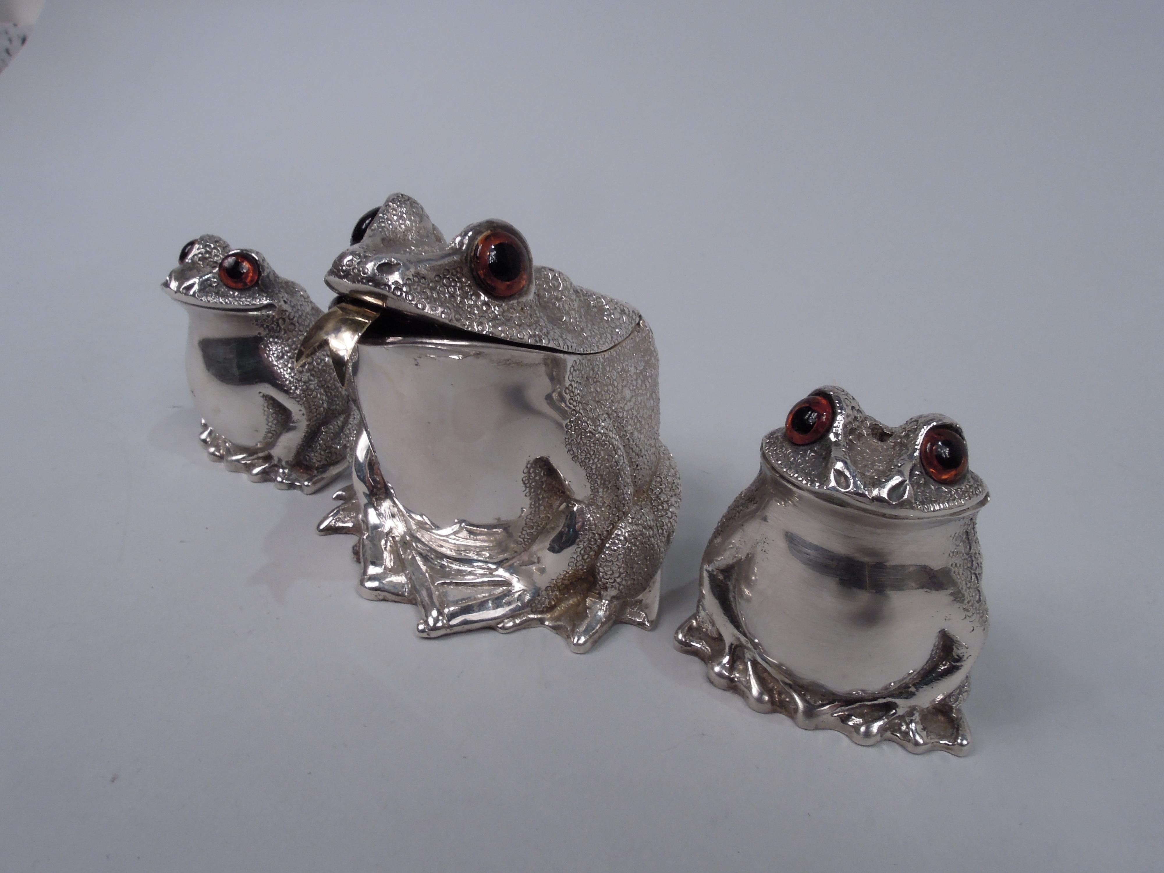 Elizabeth II sterling silver figural cast condiment set. Made by Richard Comyns in London in 1980. This set comprises mustard pot and salt and pepper shakers.
Each: A squatting, smirking frog with glass exophthalmic eyes and scaly back and