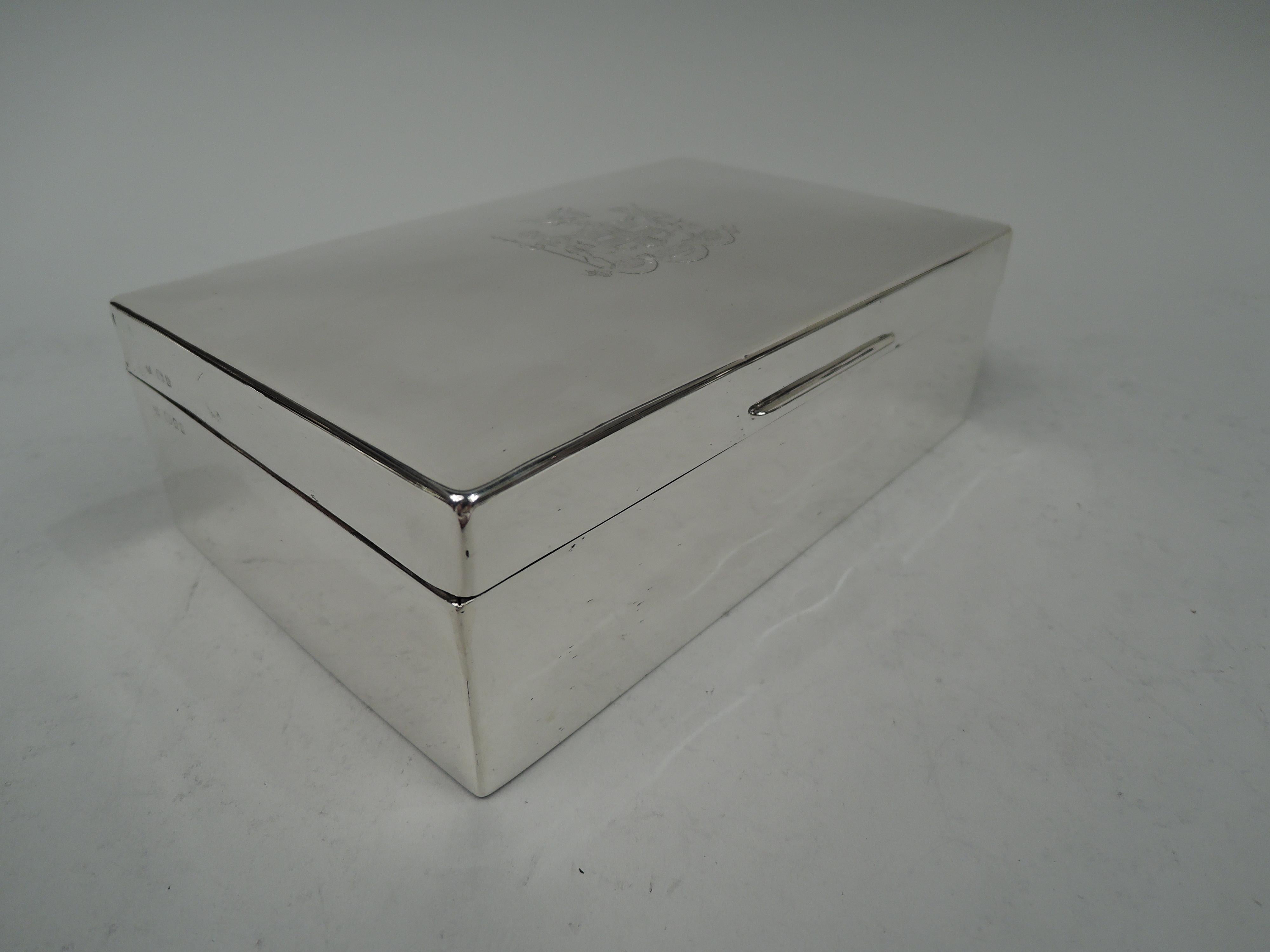 George V sterling silver box. Made by Richard Comyns in London in 1934. Rectangular with straight sides and curved corners. Cover hinged with gently curved top and tapering tab. On cover top is engraved the coat of arms of the Honourable Artillery