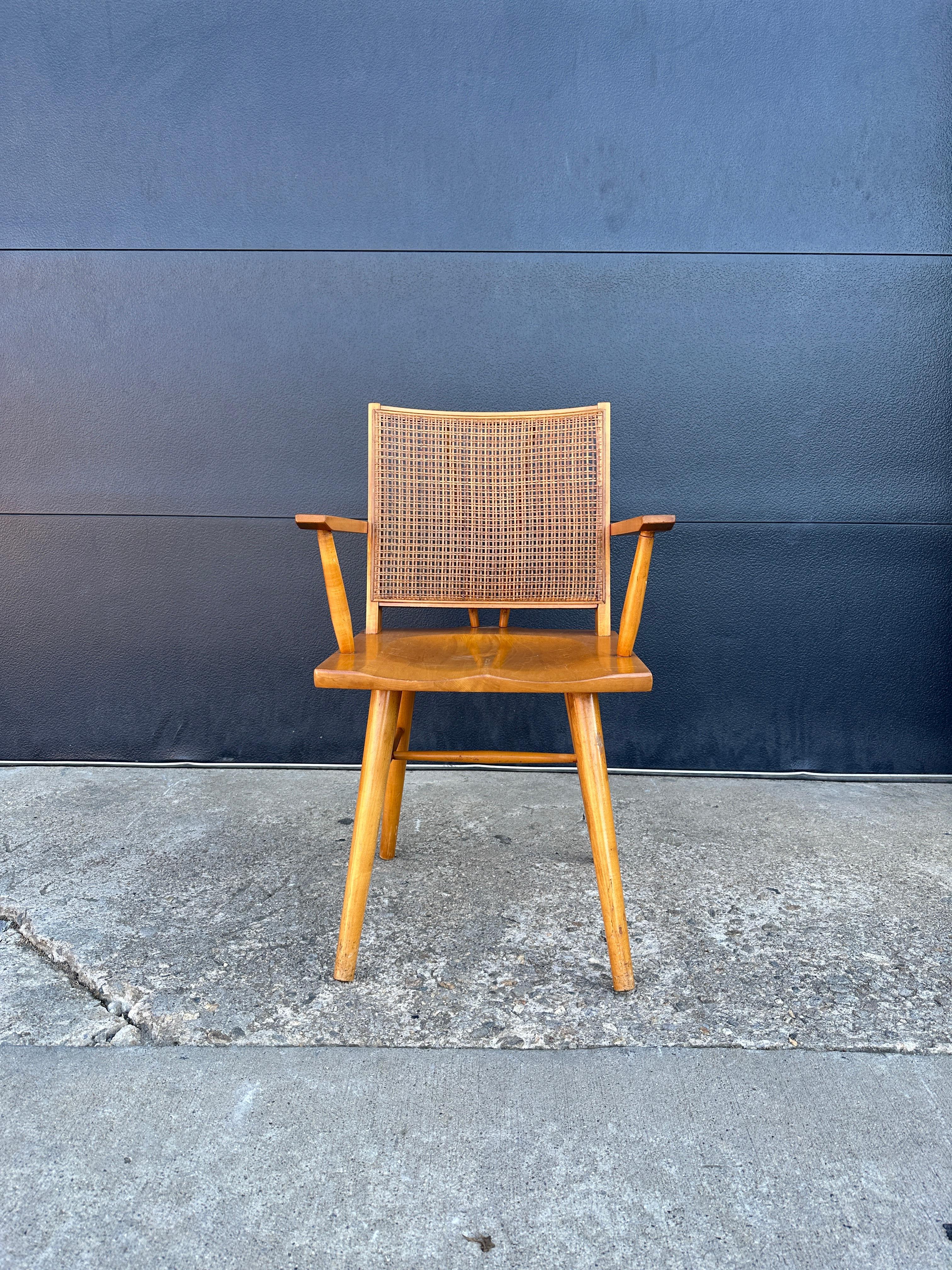 Solid maple and cane back armchair designed by Leslie Diamond for Conant Ball. Good overall condition and structurally sound and sturdy construction featuring a clean cane back with nicely tapered legs, stretcher base, contoured seat, curved and