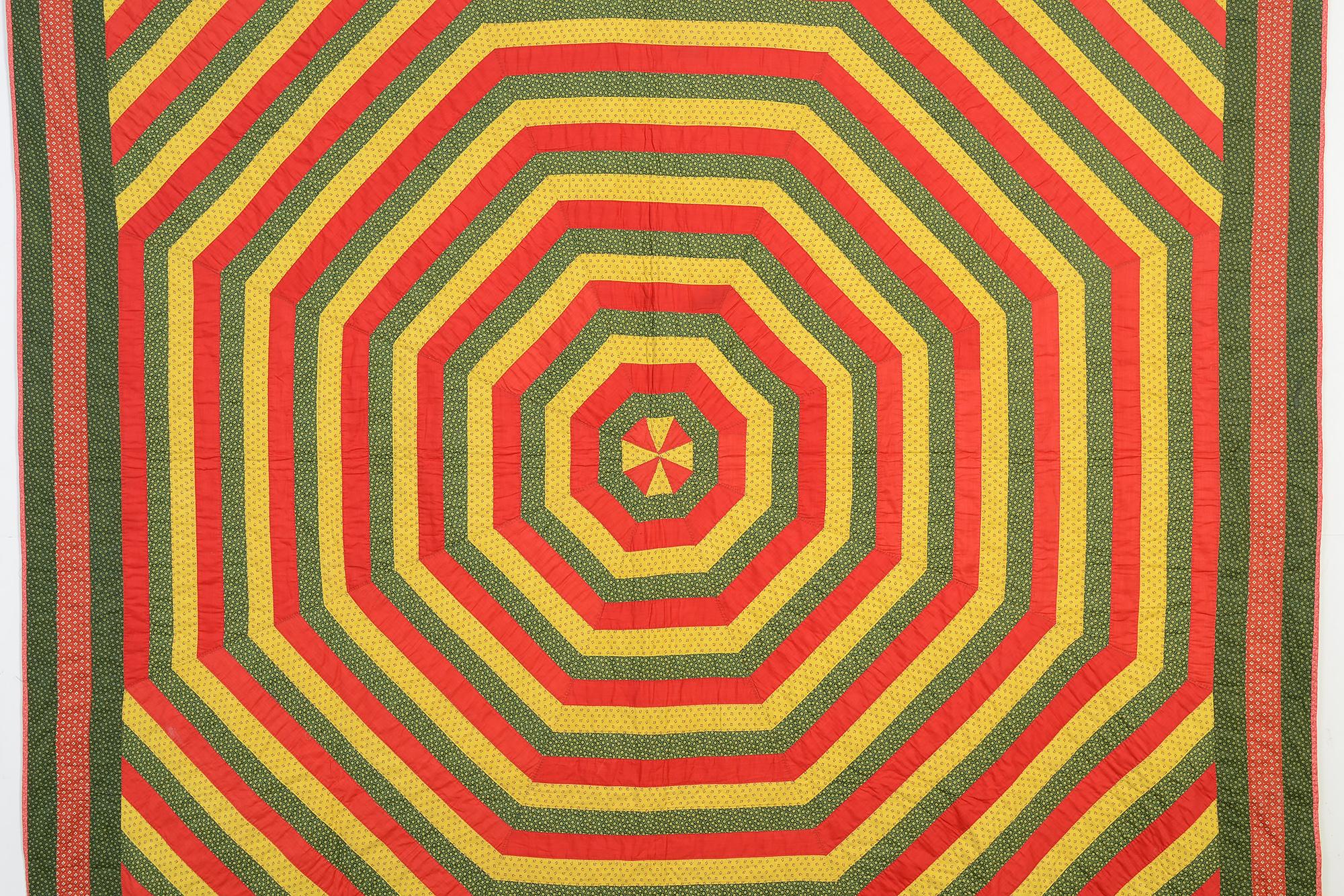 This stunning quilt of Concentric Octagons is a real eye dazzler. The Pinwheel center draws the eye to the heart of the bullseye. The fabrics are all prints with the exception of the solid red which adds to its prominence. The quilt is from the
