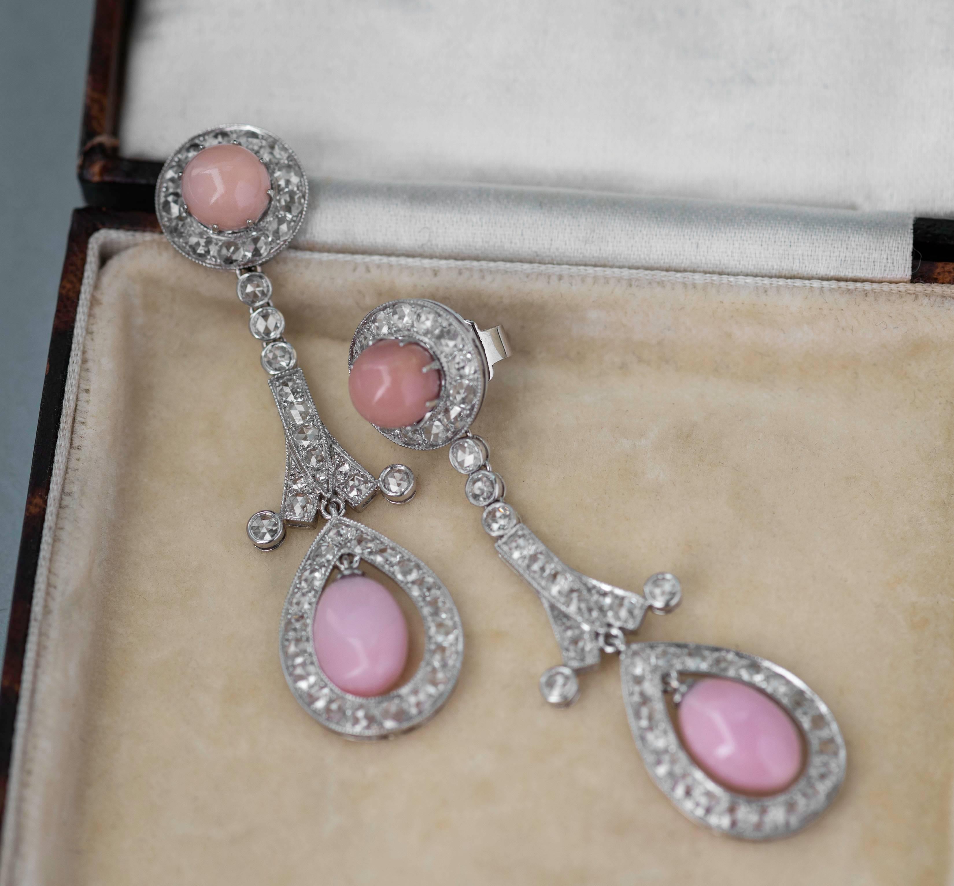 These stunning pink conch pearl and diamond earrings are such an elegant and feminine addition to any jewellery collection. Each earring has two conch pearls, one free hanging oval-shaped and one round set in a diamond cluster at the top. Between