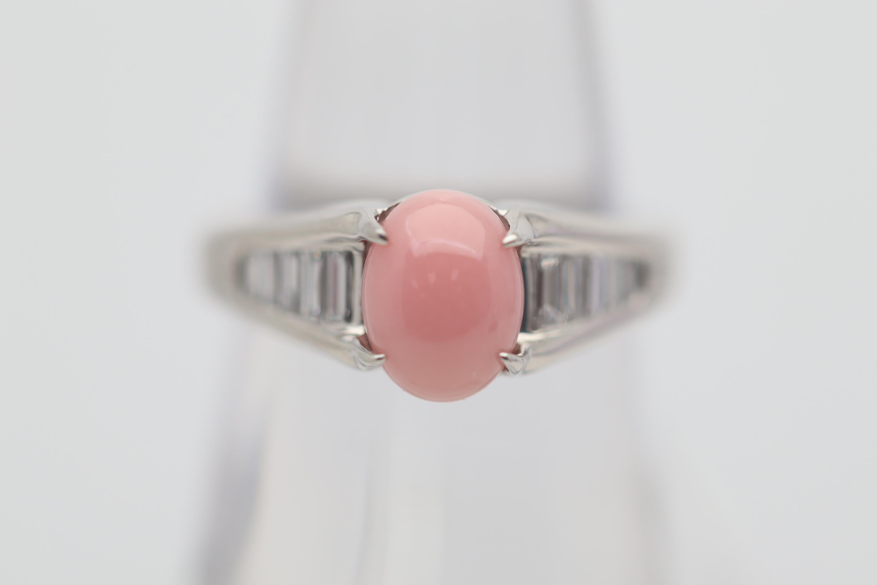 A chic and elegant ring featuring a fine conch pearl weighing 2.49 carats. It has the ideal pure and even pink color with a fine flame pattern which rolls across the pearl when a light hits it. It is complemented by 0.29 carats of baguette-cut