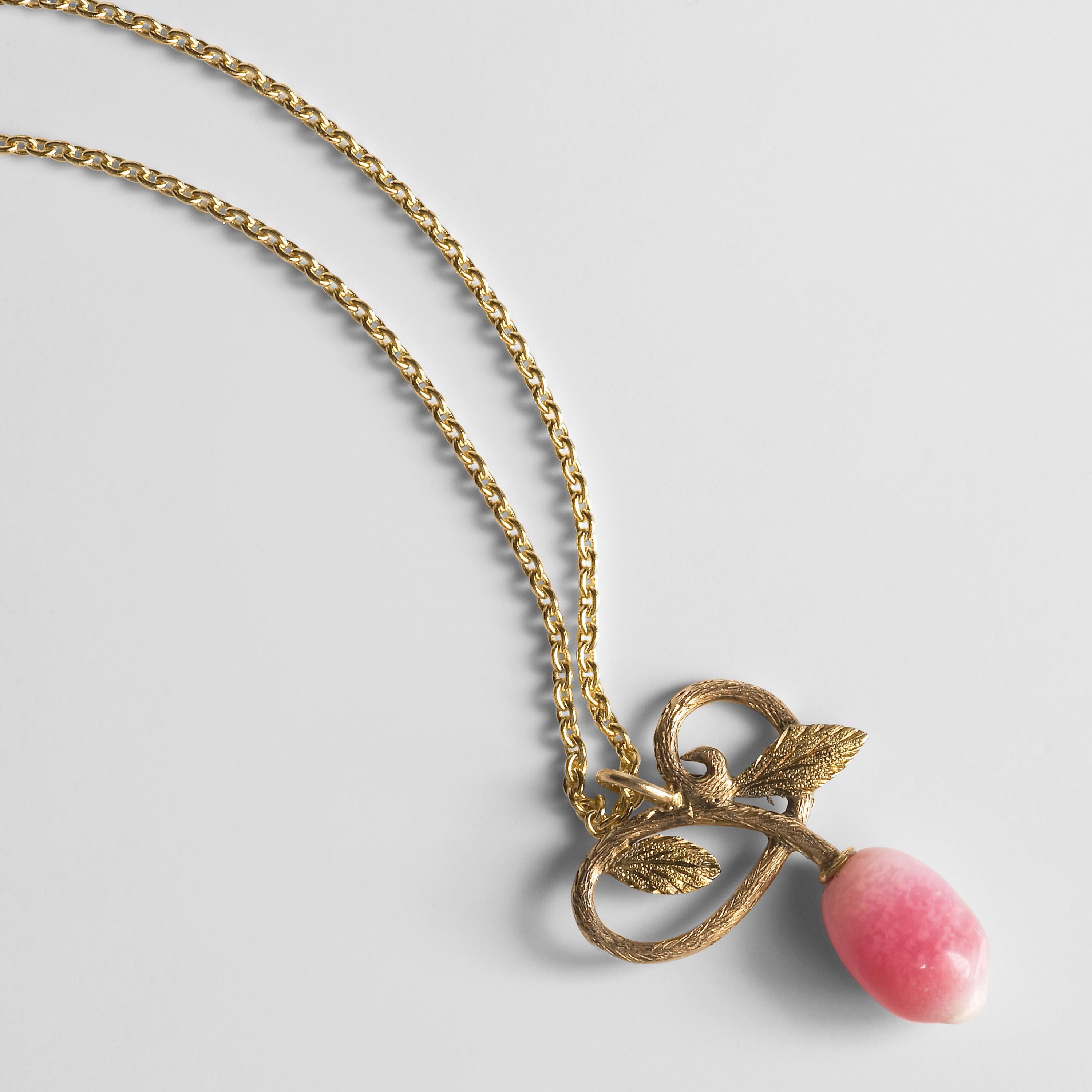 This delicate late Victorian-era (circa 1900) pendant depicts a pair of deeply engraved leaves with looping stems, below which is the most delectable fruit: a precious conch pearl. The pearl has been certified by the GIA to be a natural and