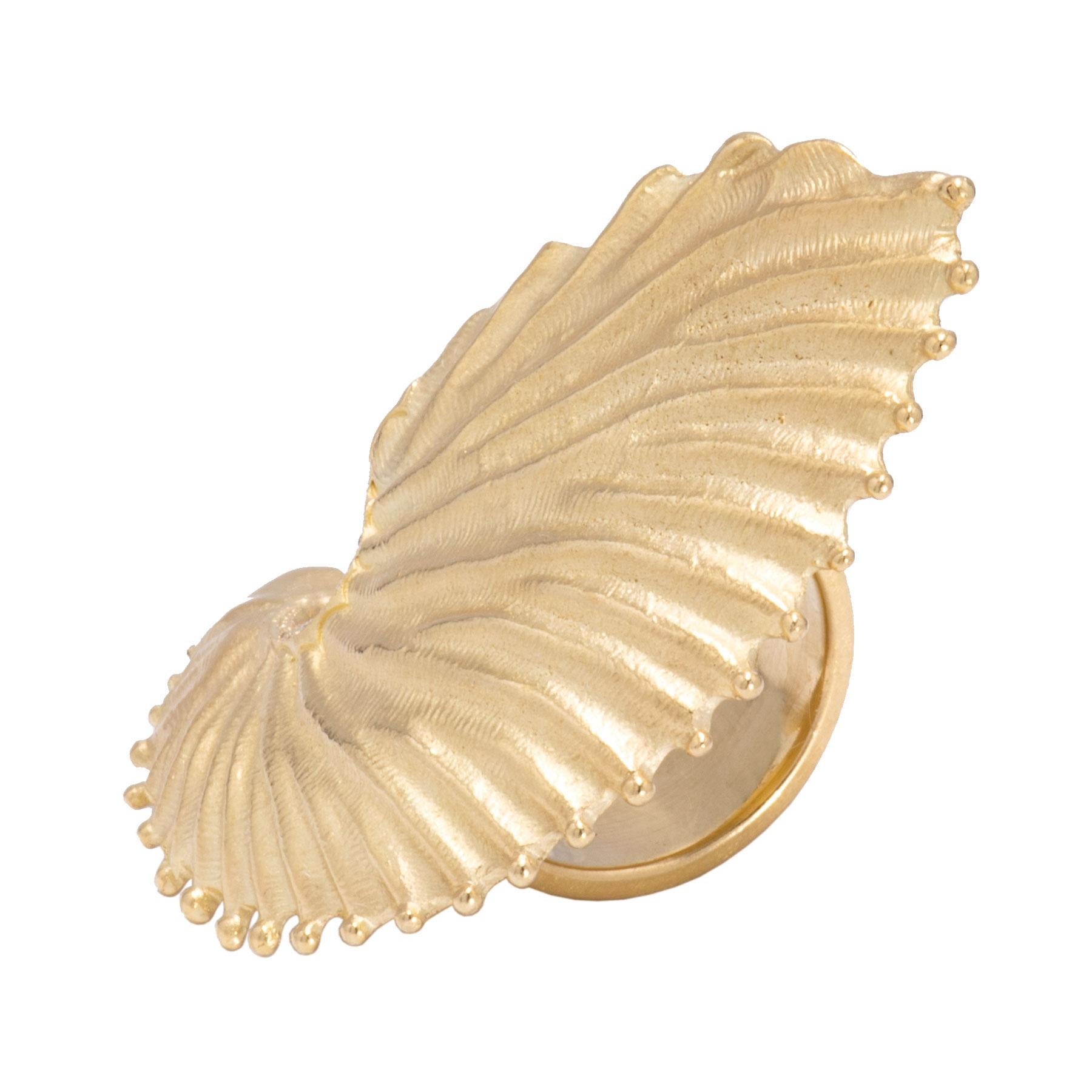 A beautifully carved section of a conch shell flares across the hand in this eye-catching statement ring. A fine line of white diamonds is set at the base as delicate as drops of sea water. Hand crafted in our studio of 18k gold, this ring is