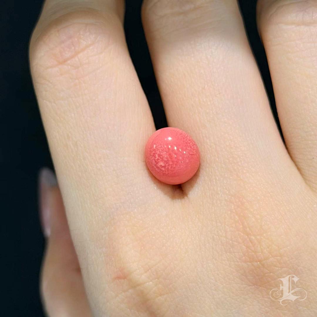 A collector’s treasure from the Conchéa collection — this exceptional natural Conch Pearl weighs 5.55 carats, measuring 10 × 9.3 mm.
Displaying an intense flaming coral-pink hue with a fully developed flame structure across the entire surface, this
