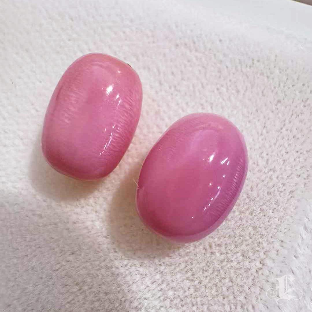 A museum-worthy pair of natural conch pearls, showcasing the coveted flamingo pink hue with full flame patterning and flawless surfaces.
Perfectly matched in size, shape, and color saturation, these rare gems weigh 4.73ct and 4.87ct respectively and
