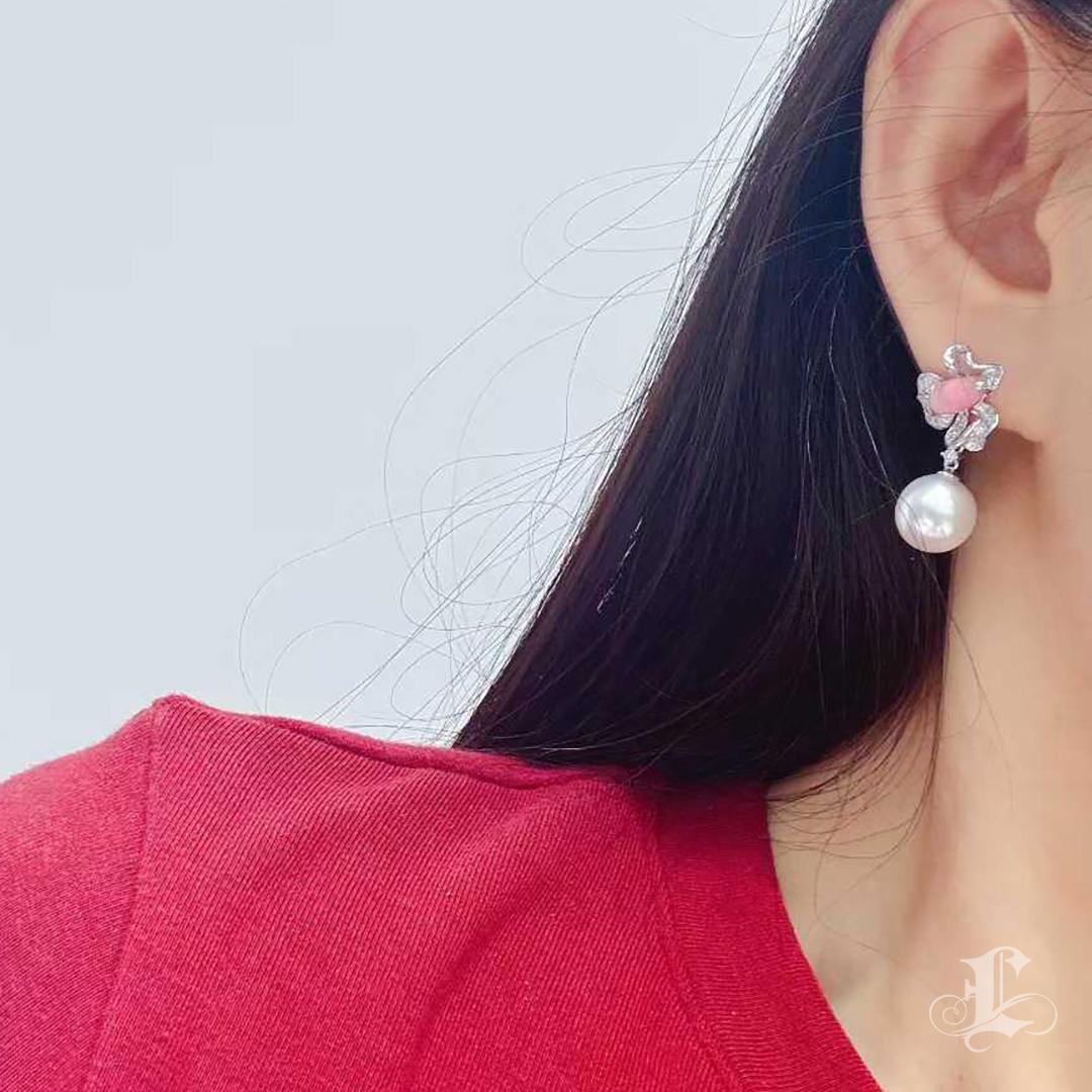 Ces boucles d'oreilles présentent deux perles de conque roses naturelles (2,34 ct au total), délicatement teintées d'un doux blush avec des motifs de flammes partielles et des pointes de calcium naturelles. Chacune est gracieusement rehaussée de