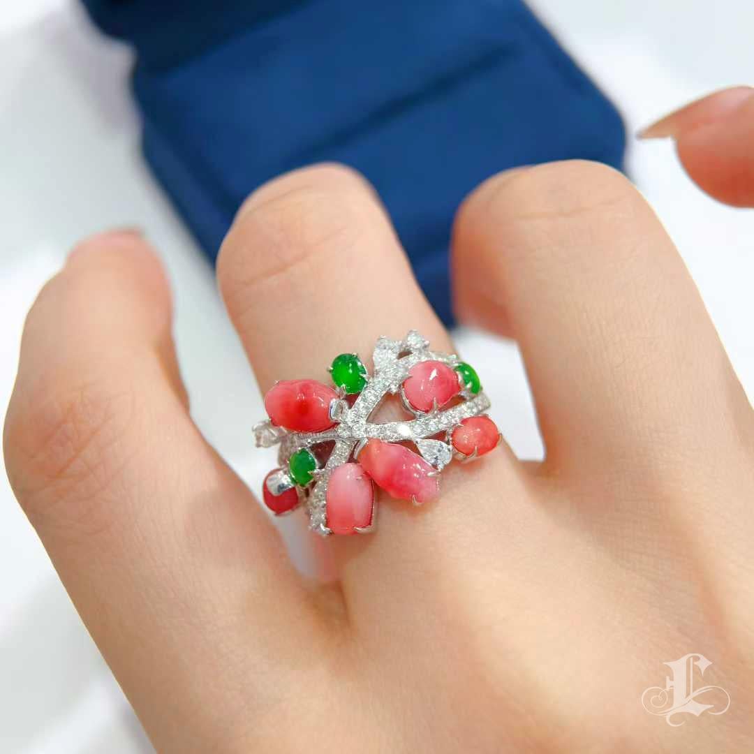 Una vivida dichiarazione dell'arte della natura.
Le perle di conchiglia rosa intenso (4,37ct in totale), ciascuna con accenni di fiamma, sbocciano come fiori rari su un reticolo di diamanti incastonati. I brillanti accenti di giadeite in verde