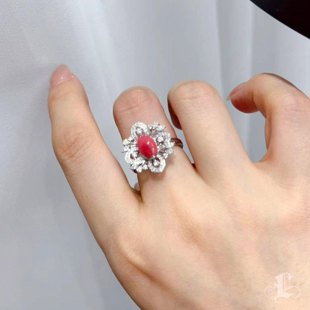Ein exquisites Blumenwappen, das mit natürlicher Seltenheit blüht.
Im Mittelpunkt dieses einzigartigen Rings steht eine 1,87-karätige, natürliche Muschelperle in einem tiefen Rosaton, die sich durch ein ganzflächiges Flammenmuster auszeichnet - ein