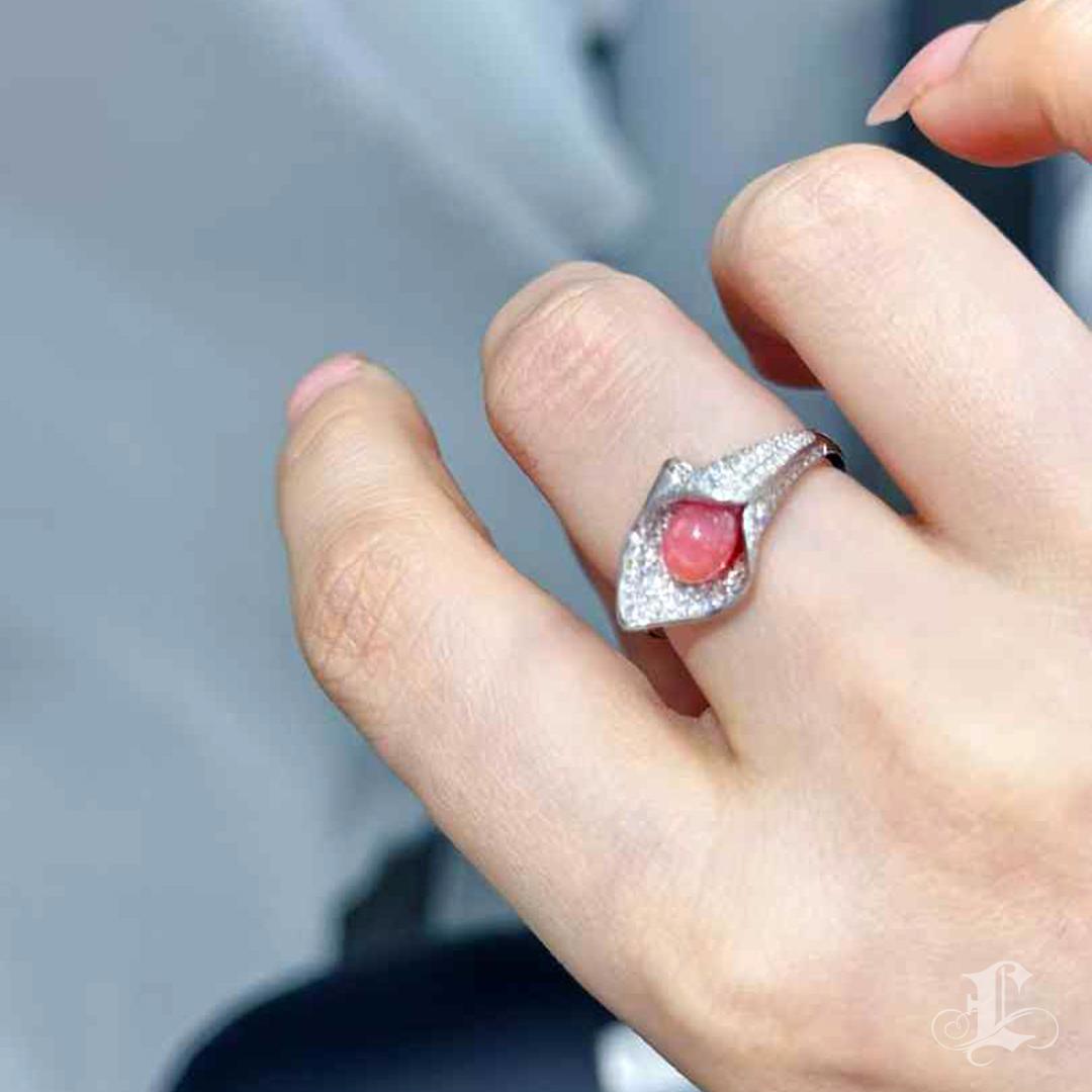 Une perle de conque naturelle lumineuse de 1,19ct, d'un rose flamant, est nichée dans une monture stylisée en forme de pétale, rehaussée de 0,48ct de diamants taillés en brillant. La perle présente un motif de flamme de flocon de neige rare et