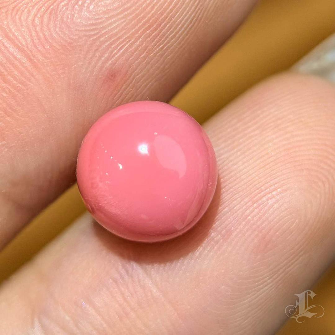 Una verdadera joya de coleccionista: esta rara perla natural de Concha brilla con un intenso tono rosa flamenco y un fino dibujo de llama.
Su forma perfectamente redonda y su color saturado representan la cumbre del arte de la naturaleza,