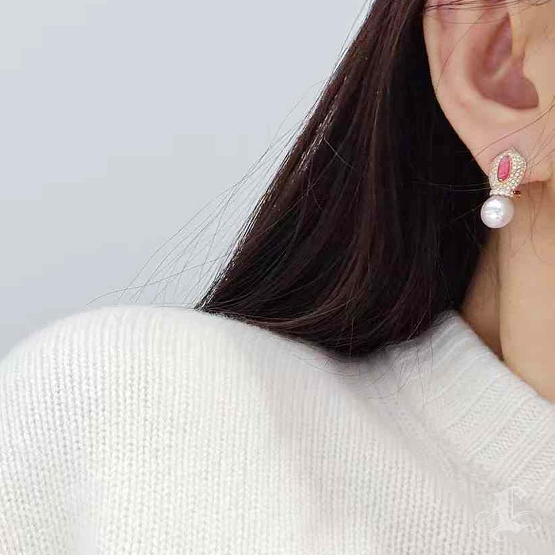Ode raffinée au mystère et au mythe, ces boucles d'oreilles enchanteresses s'articulent autour d'une paire de perles de conque naturelles totalisant 0,97 carat - chacune affichant une teinte rose foncé vive avec de délicats motifs de flammes.