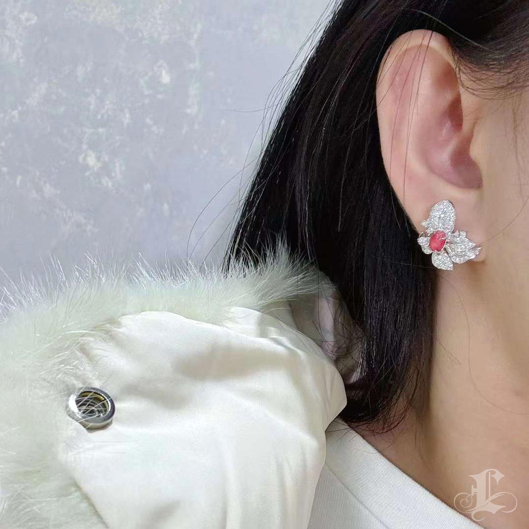 Un raro incontro con l'arte della natura: la morbida fiamma rosa delle perle di conchiglia sboccia in un giardino di diamanti. Scolpita a forma di petali di orchidea, ogni curva riflette eleganza e rarità, catturando l'essenza della bellezza fugace