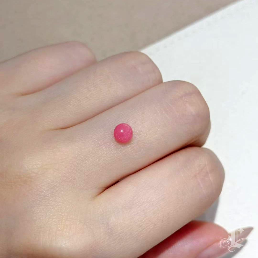 Trésor rare de la mer, cette perle de conque naturelle présente une teinte rose flamant exceptionnellement saturée, une forme ronde presque parfaite et un motif de flamme plein et vif sur toute sa surface. Avec ses 5,2 mm et ses 0,88 carat, sa