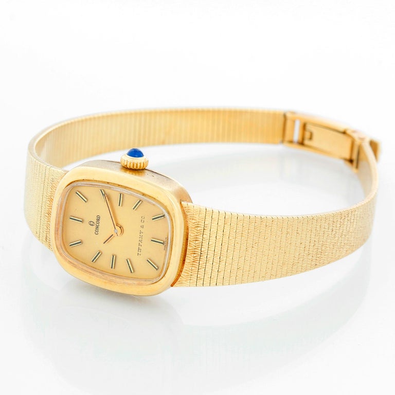 Concord for Tiffany & Co. Yellow Gold Ladies Watch - Manual winding. 14K Yellow gold (18 mm) inscription on case back . Champagne dial with stick hour markers. Integrated 14K Yellow gold mesh bracelet ( will fit a 6 1/2 inch wrist). Pre-owned with
