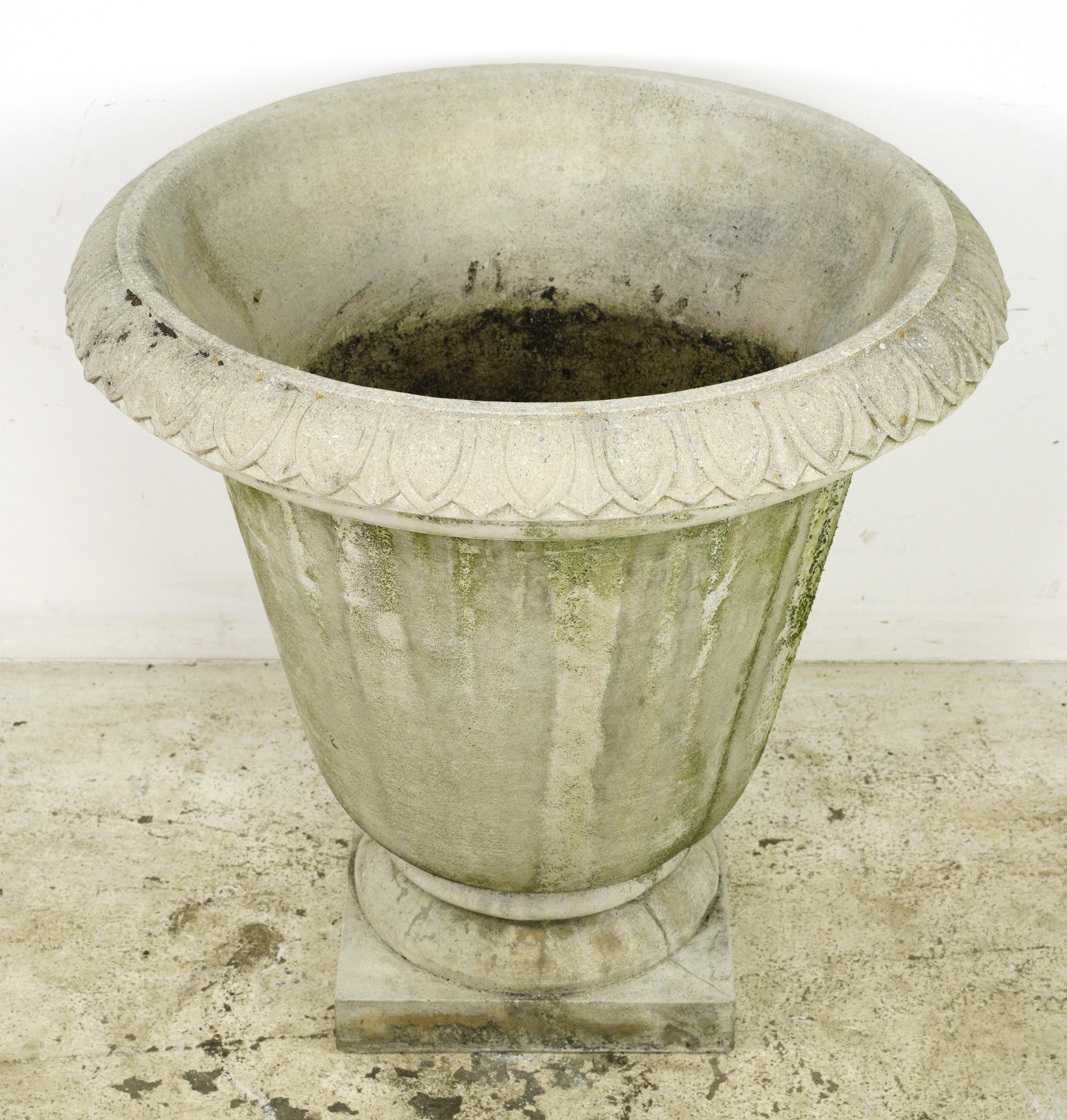This urn shaped planter boasts a timeless design featuring egg & dart trim detailing. Crafted from durable concrete, it provides a sturdy and reliable container for your plants. Whether used as a standalone decorative piece or filled with vibrant