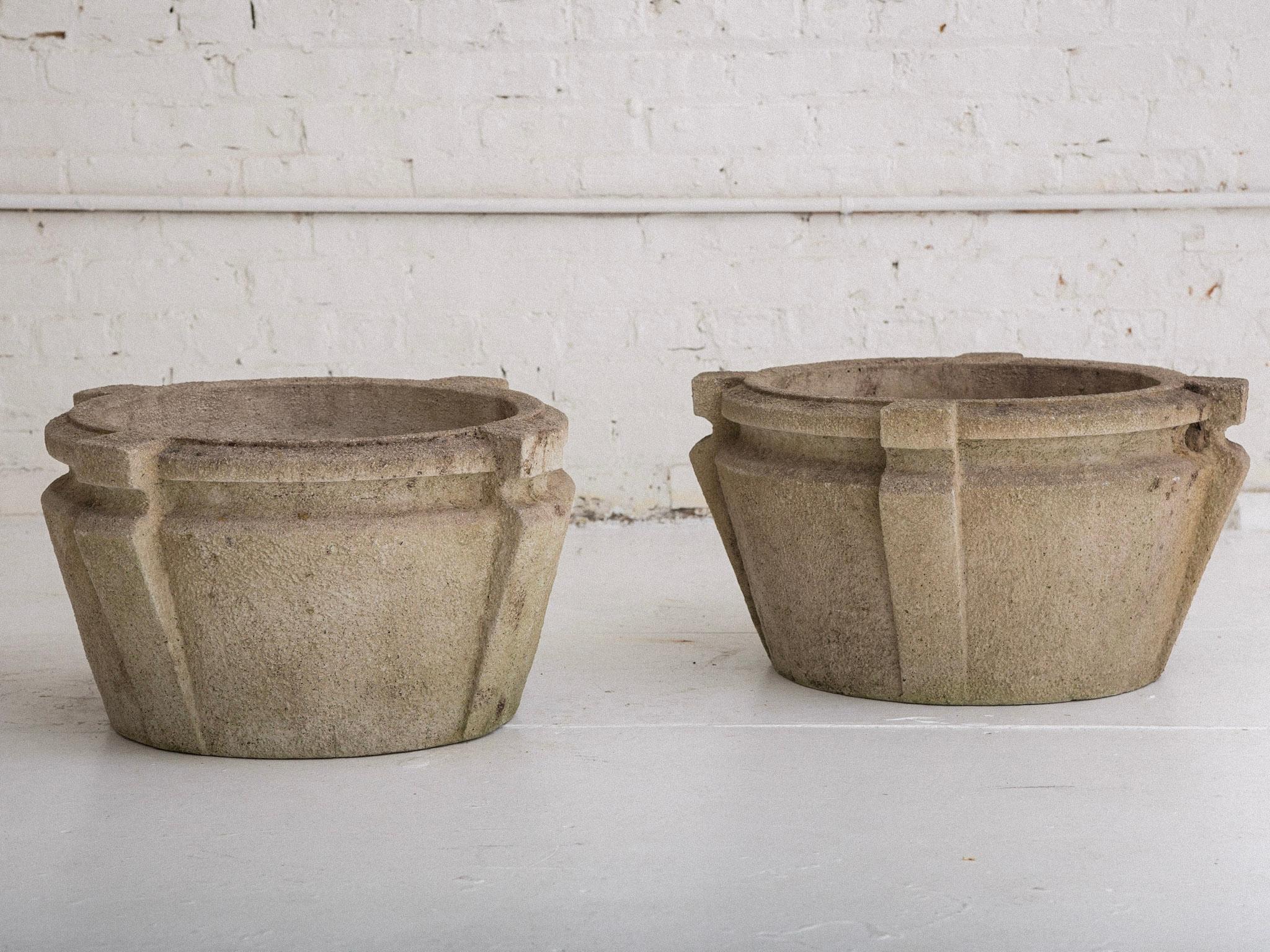 A pair of cement planters. Arts & Crafts / craftsman style. Large and heavy made of solid cement. Features holes for drainage. Weathered patina. Manufactured by Nina Studio, Quakertown, PA. circa 2000.