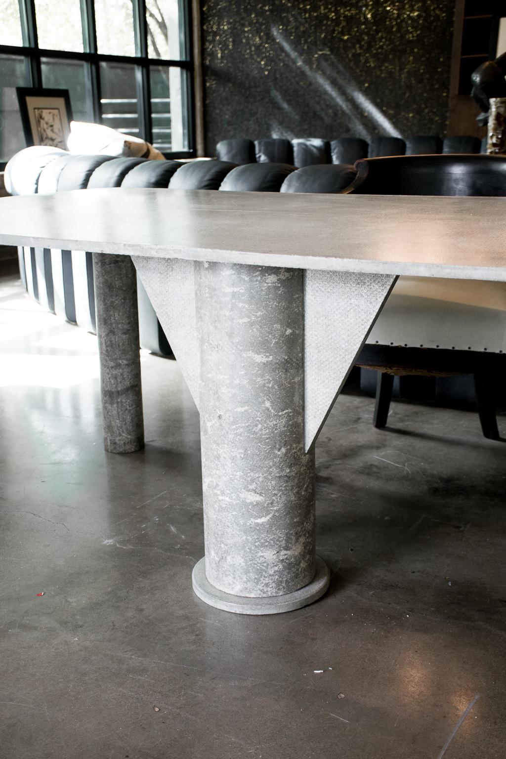 Generously scaled desk of concrete composite with geometric pedestal and cylindrical legs. Italy, 1980s.