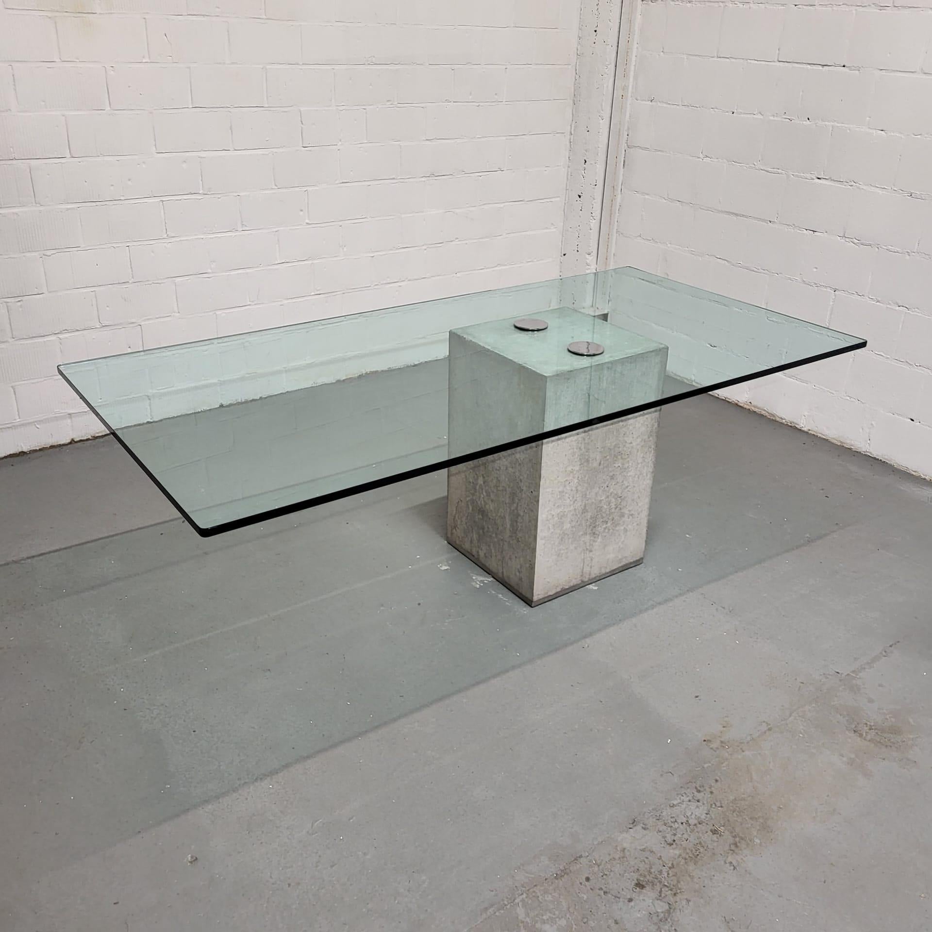 Concrete and chrome dining table with thick clear glass top.

Designed by Sergio and Giorgio Saporiti for Saporiti.

This concrete dining table is a beautiful eye catcher and unique thanks to the not centered table base. 

The top is strongly