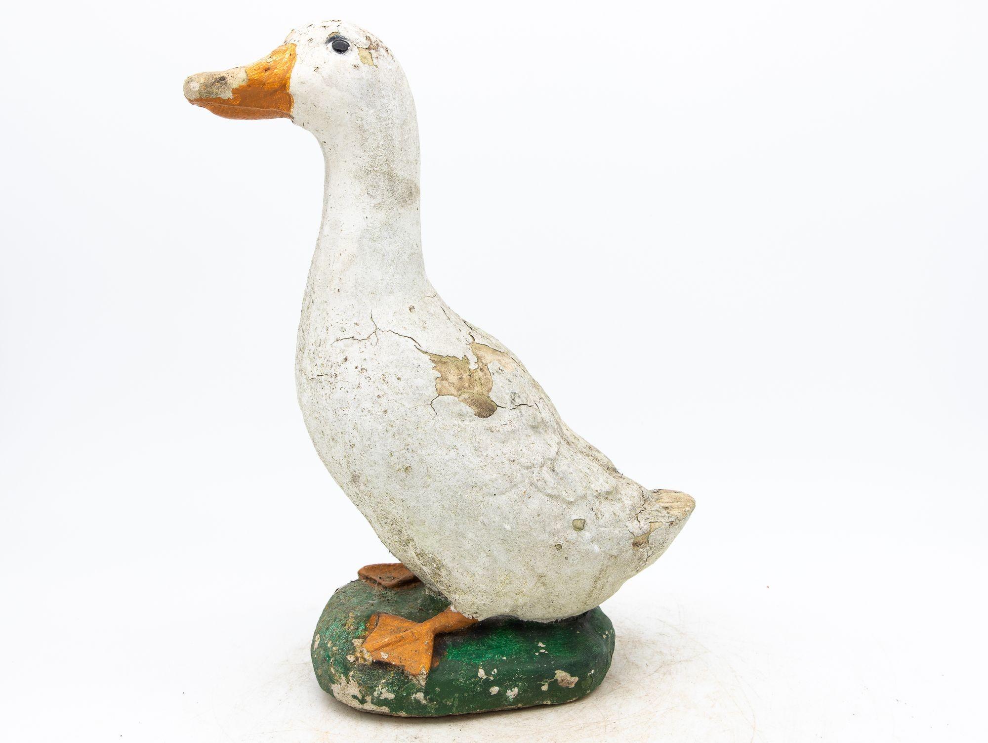 Capture the enchantment of a vintage French garden with this charming duck ornament. Crafted from durable concrete, it stands as a testament to both artistry and timelessness. The honest patina adorning the surface with white, green, and orange