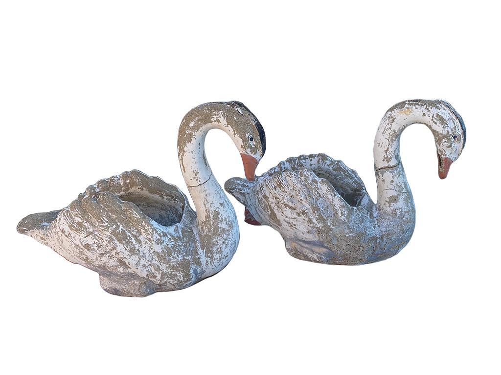 1950s Concrete swan planters a pair. These swans are a classic outdoor accessory and have great appeal right now and this pair has a great sense of history. Naturally aged beautiful painted patina. Flecks and cracks are surface and can be fixed if