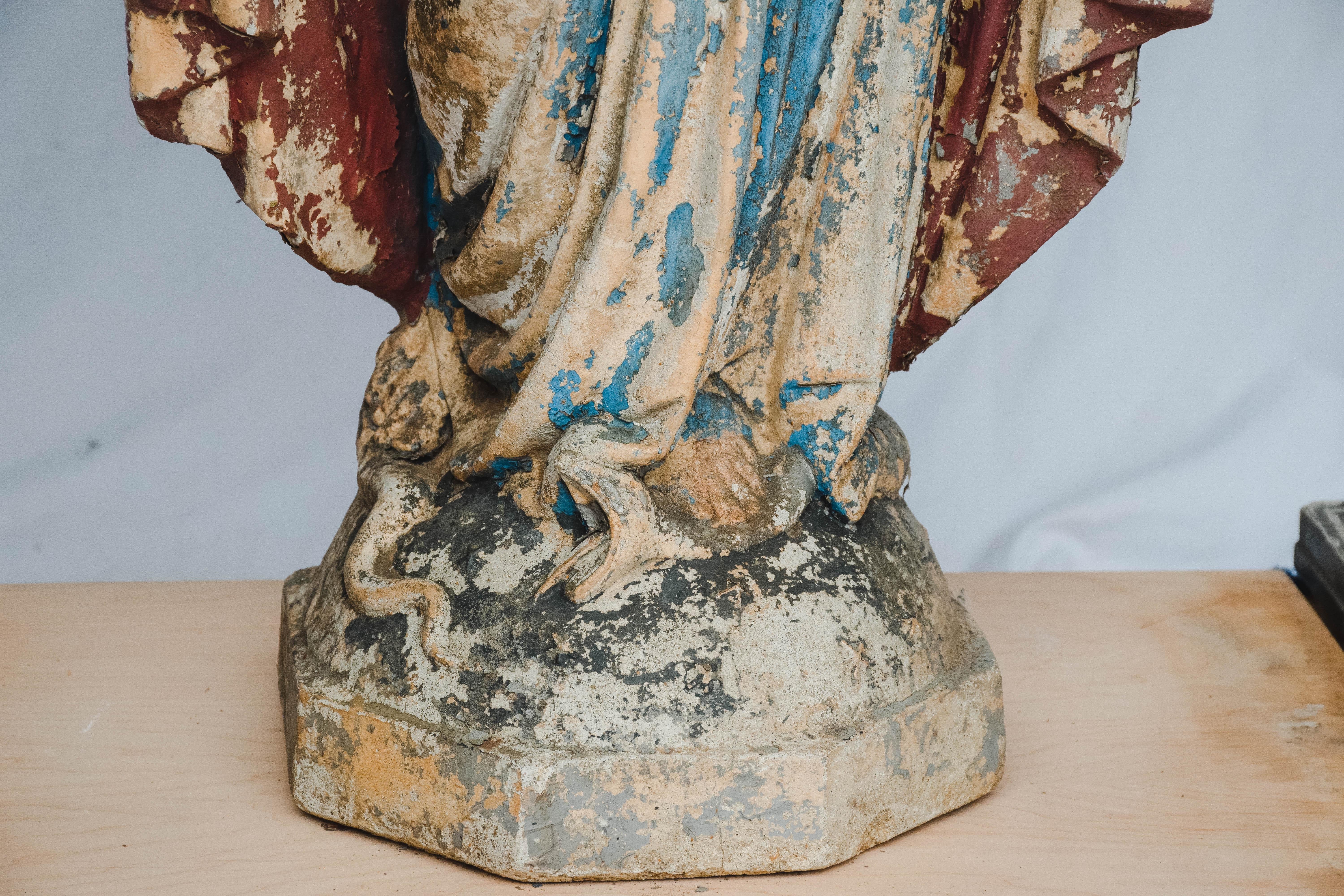 This is a concrete statue of The Virgin Mary. We believe this statue was once used outside of a church. The paint has worn leaving a wonderful aged patina. This beautiful statue could be used in your home or garden.