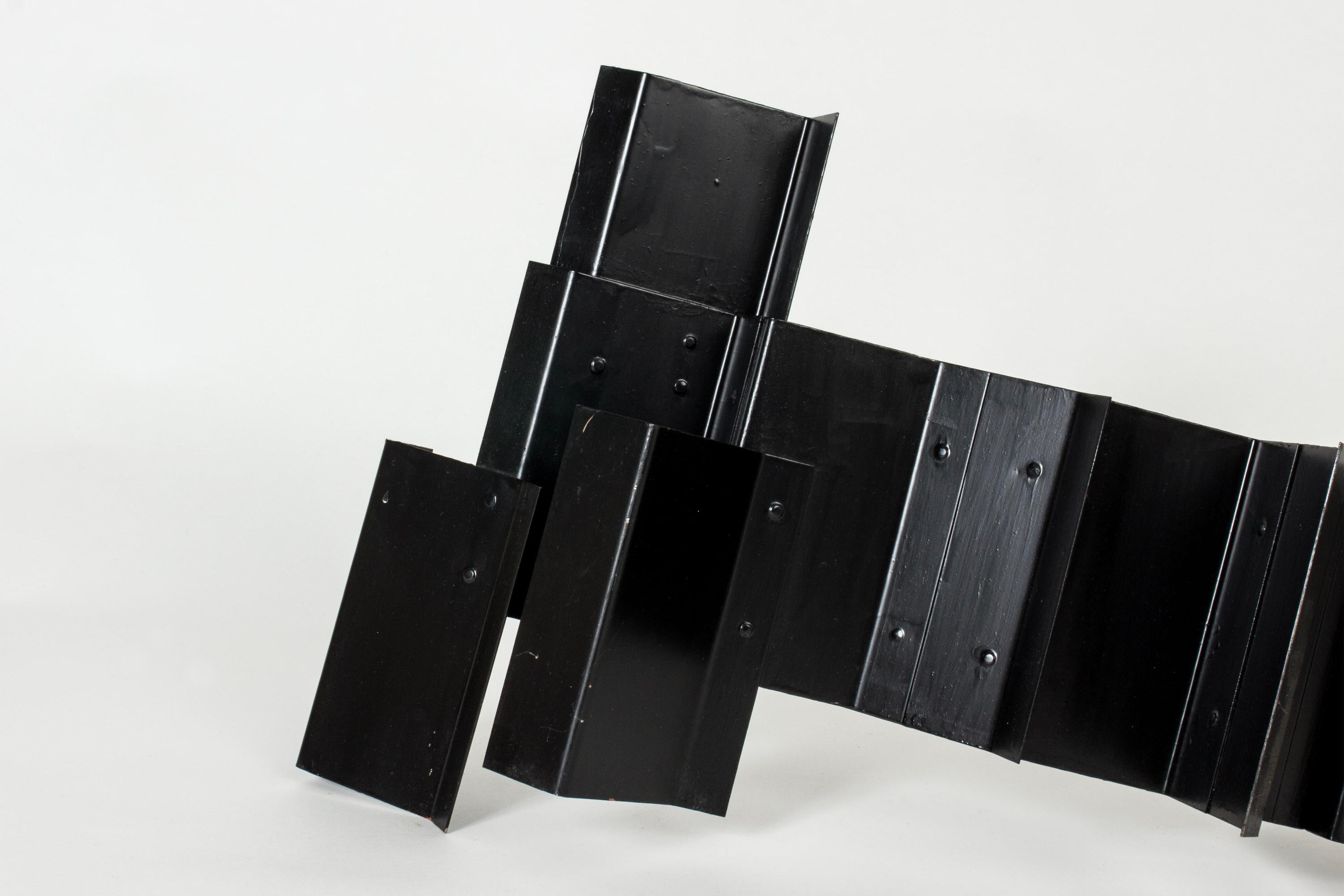 Striking sculpture by Lars Erik Falk, made from black lacquered metal. Interesting angles, different perspectives from different angles. 

Lars Erik Falk (1922-1918) was one of Sweden’s foremost constructivists. He was a painter and sculptor,