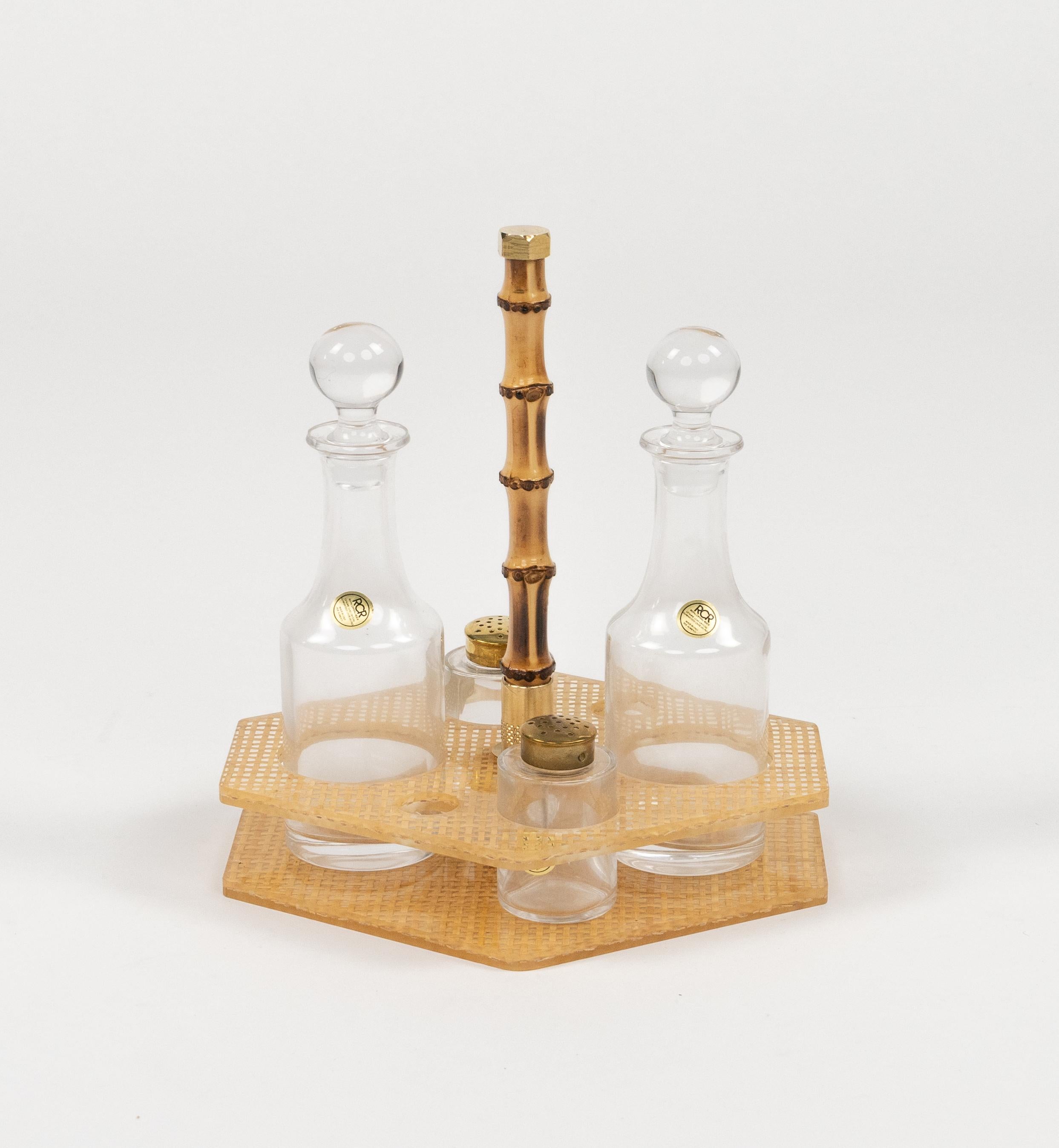 Midcentury beautiful condiment set (vinegar, oil, salt and pepper) in lucite, wicker, bamboo, brass and crystal ( Royal Crystal Rock) in the style of Christian Dior Home.

Made in Italy in the 1970.