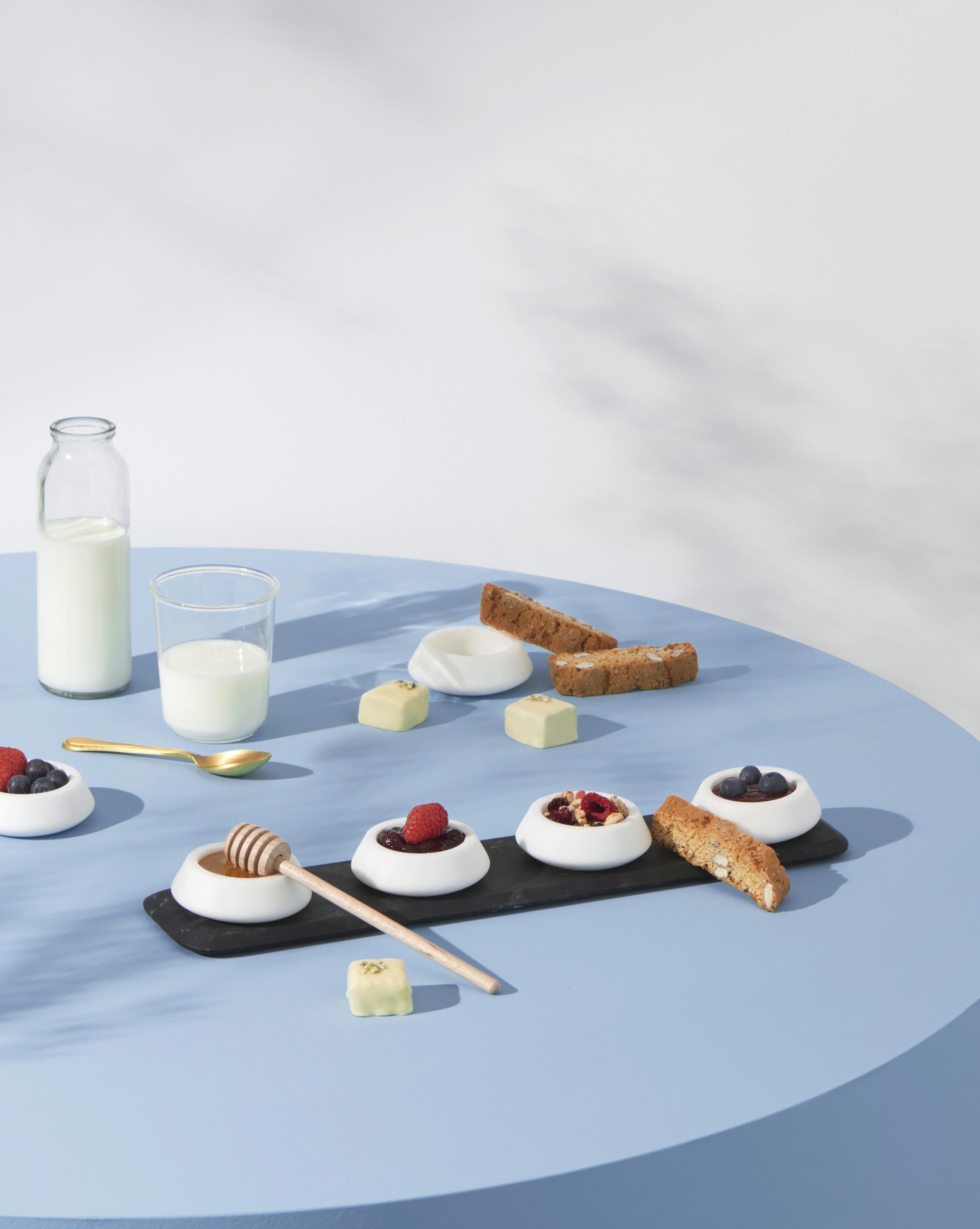 A sculptural shape for a container. Colominas’ project accomplishes curved marble that lends itself to carrying sauces or oils with designs that are always different. The item includes four white Michelangelo marble small bowls.
Size: 39.4 x 9 x 1