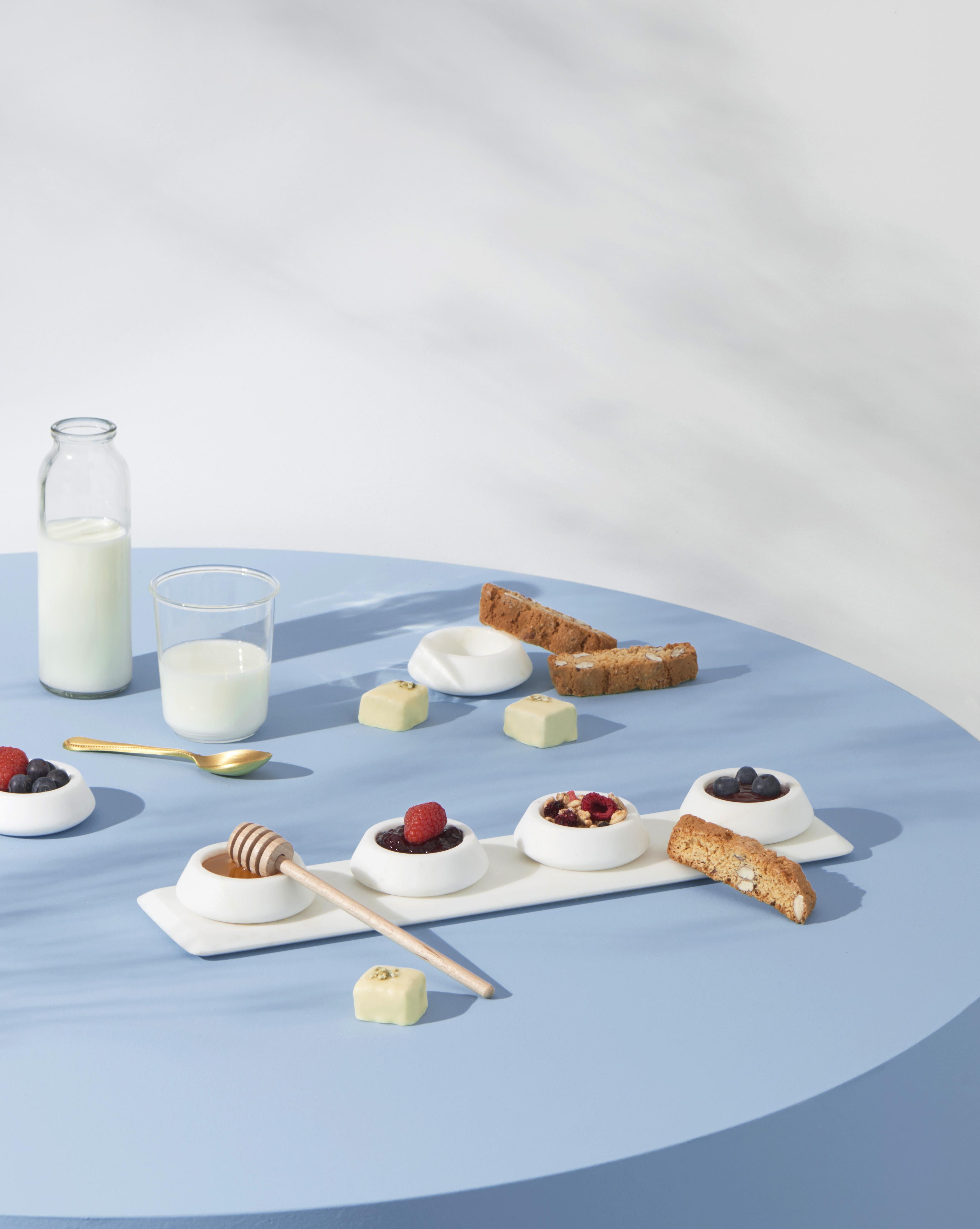 Condiment Tray and four bowls in Bianco Michelangelo marble
 
Sculptural, bright white, well-defined and multi-fold. Colominas has created a table service inspired by Angelo Mangiarotti’s soft lines, exalting the shape and structure of objects that