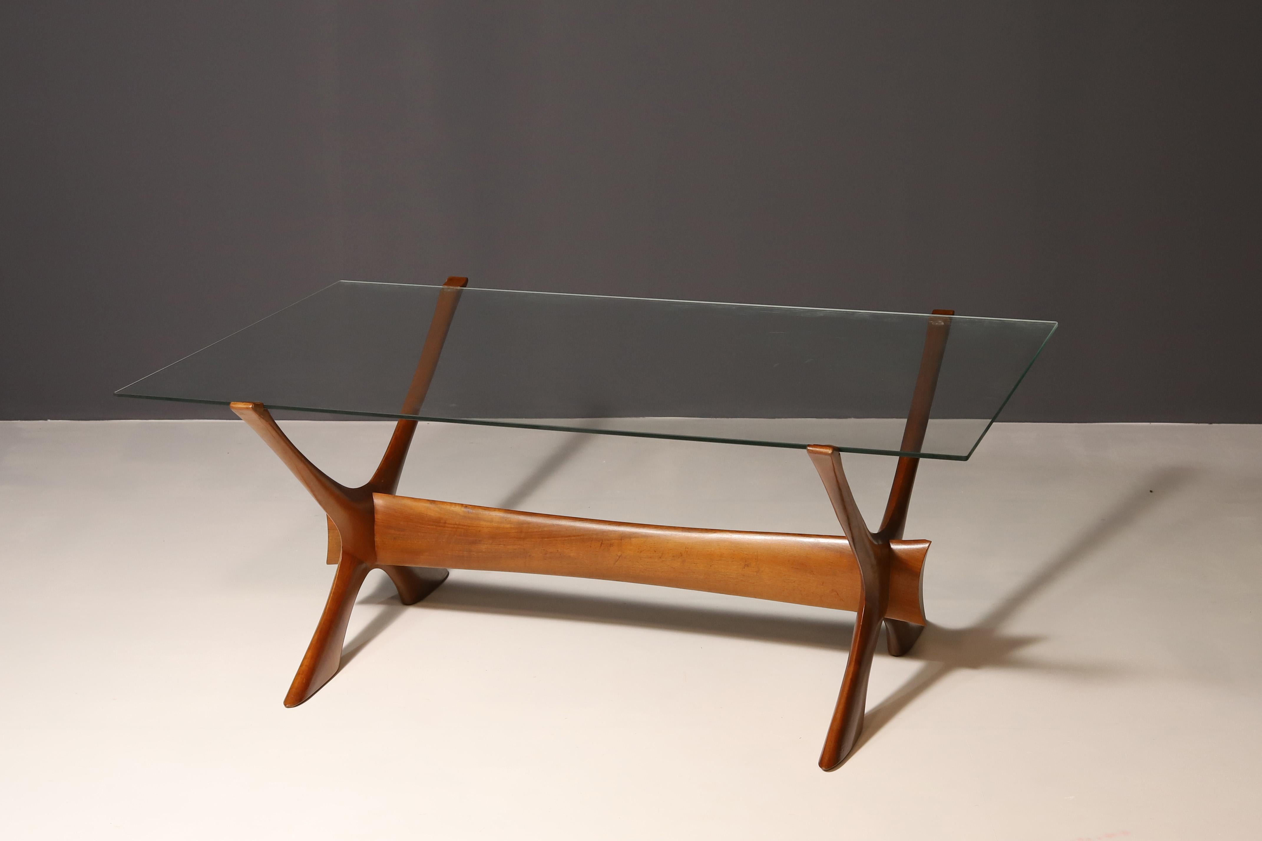 Dieser organisch geformte Condor Couchtisch wurde von Fredrik Schriever-Abeln entworfen und in den 1960er Jahren von Örebro Glass in Schweden hergestellt. Der X-förmige Sockel wurde in Handarbeit aus massivem Nussbaumholz gefertigt. Der markante