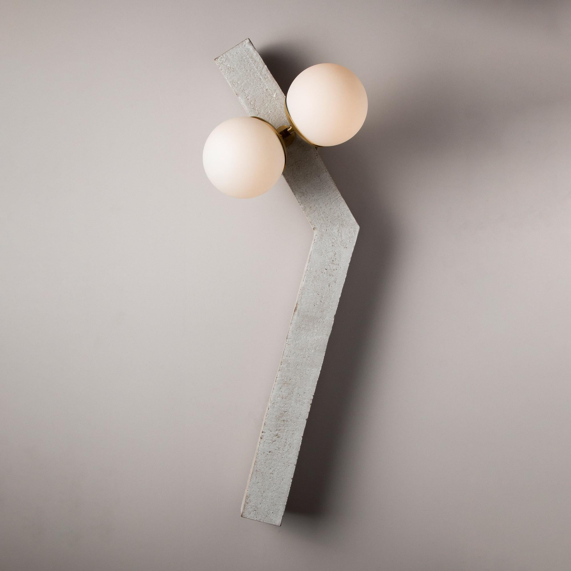 Inspired by midcentury Brutalist architecture and building materials, this playful handmade sconce balances a strong substantial ceramic base with delicate brass hardware and matte white glass. The angled ceramic center column is handcrafted from a