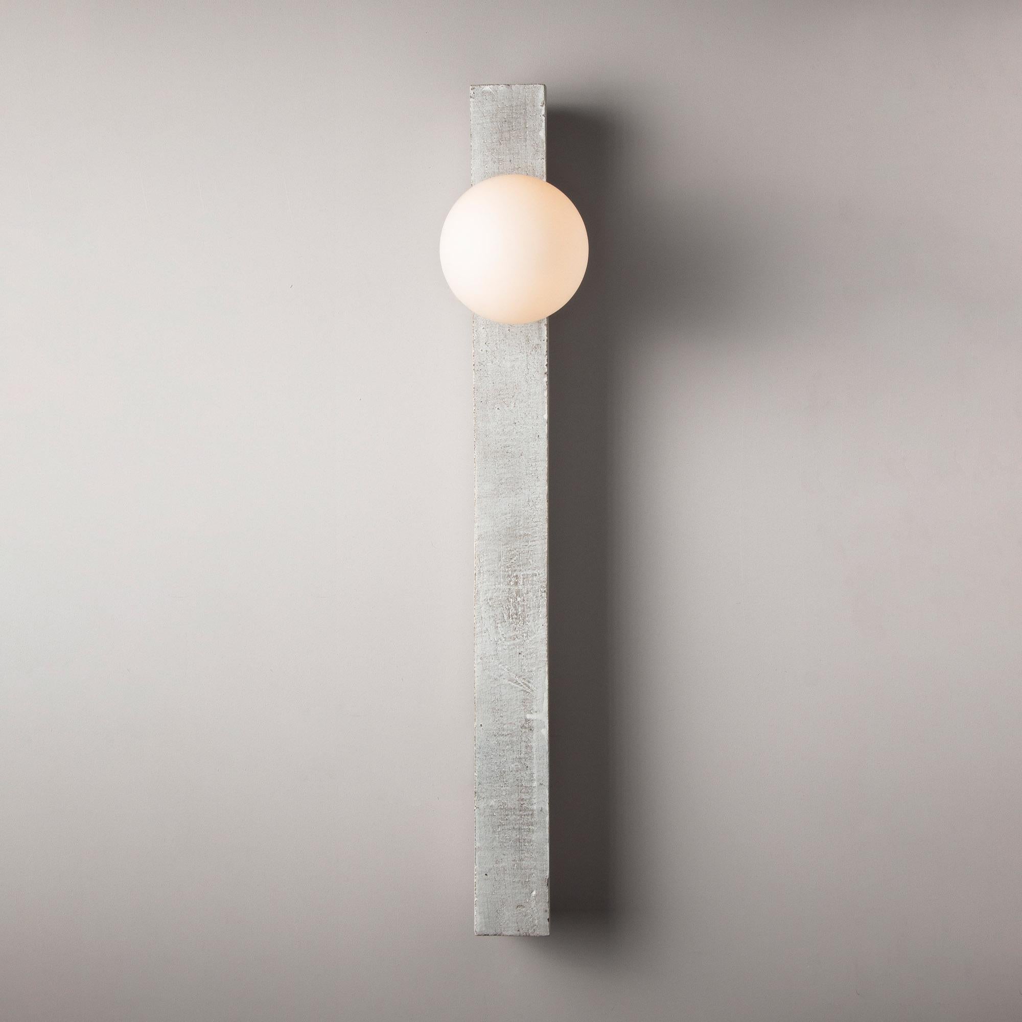Inspired by midcentury Brutalist architecture and building materials, this minimal handmade sconce balances a strong substantial ceramic base with delicate brass hardware and matte white glass. The substantial ceramic center column is handcrafted