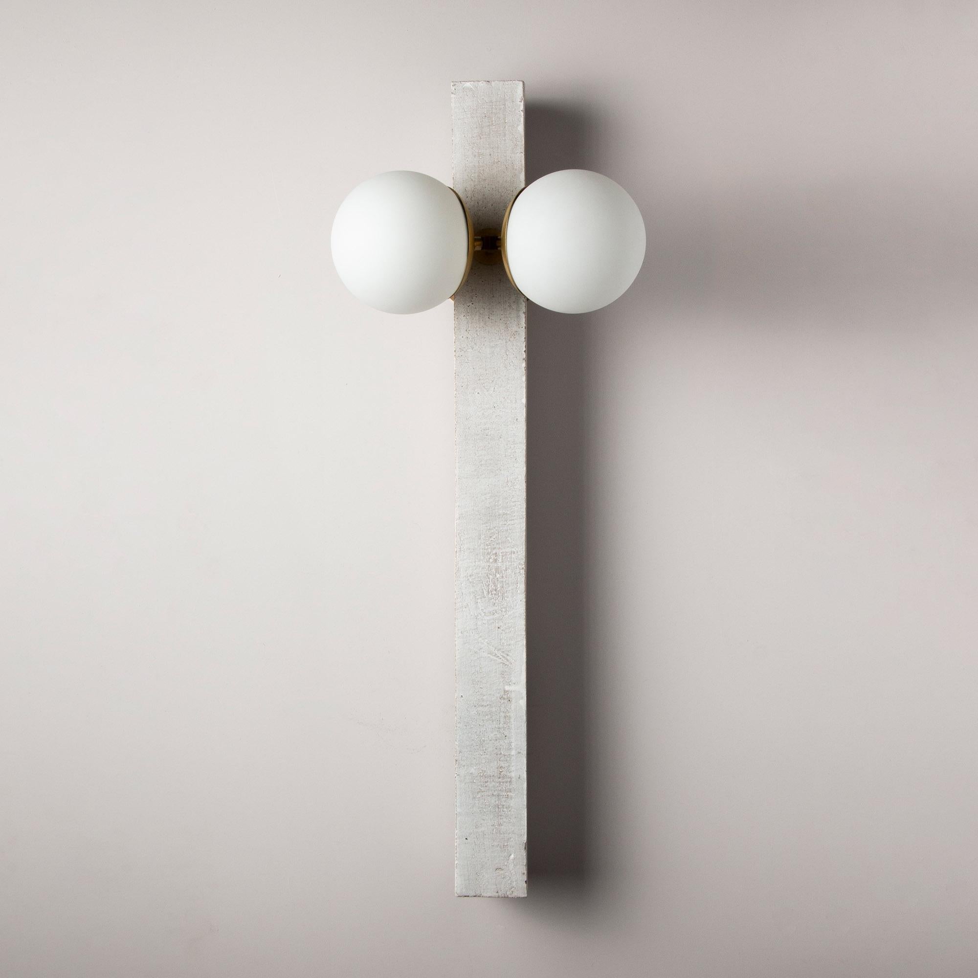 Inspired by midcentury Brutalist architecture and building materials, this minimal handmade sconce balances a strong substantial ceramic base with delicate brass hardware and matte white glass. The substantial ceramic center column is handcrafted