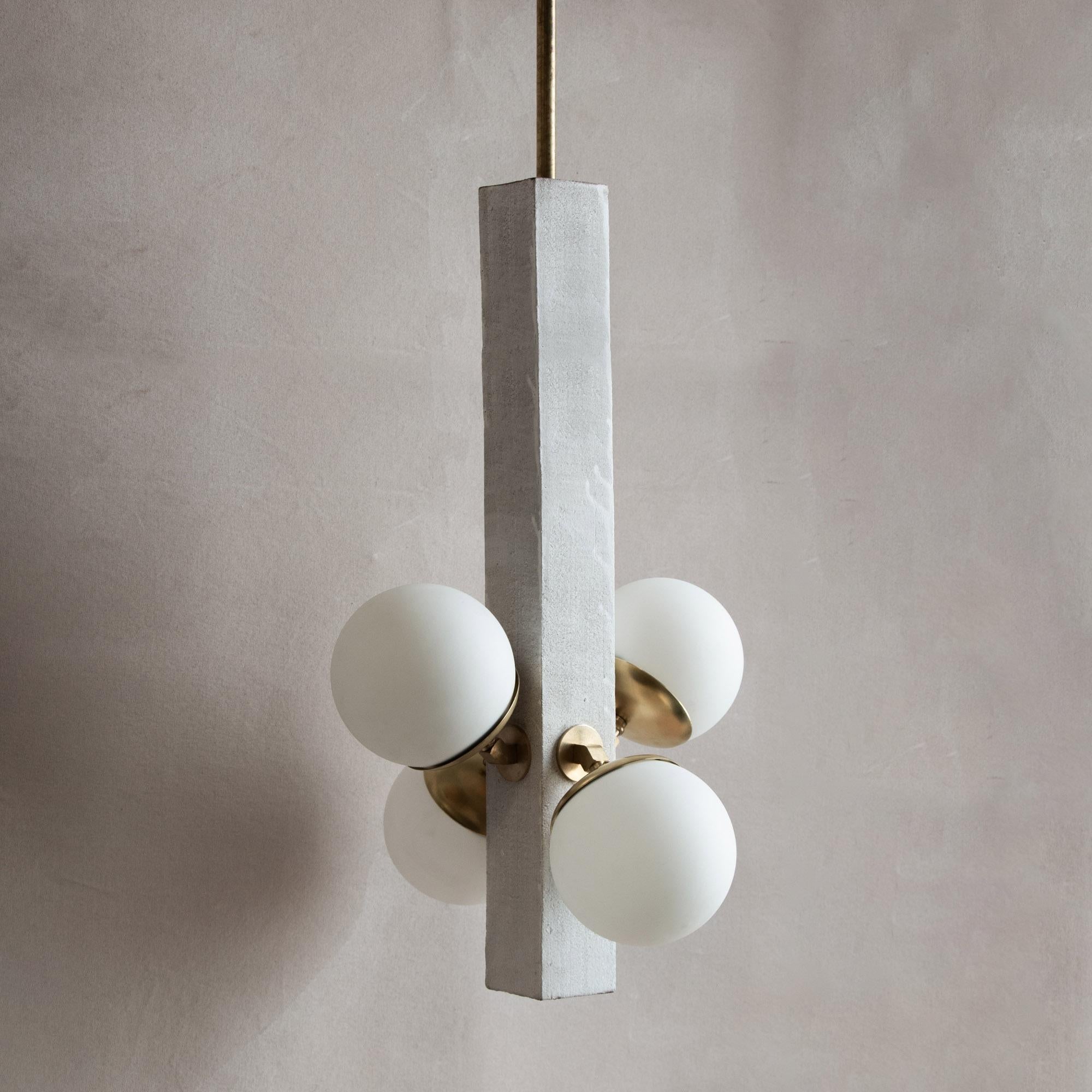 Inspired by midcentury Brutalist architecture and building materials, this playful pendant light balances a strong substantial ceramic base with delicate brass hardware and matte white glass. The substantial ceramic center column is handcrafted from