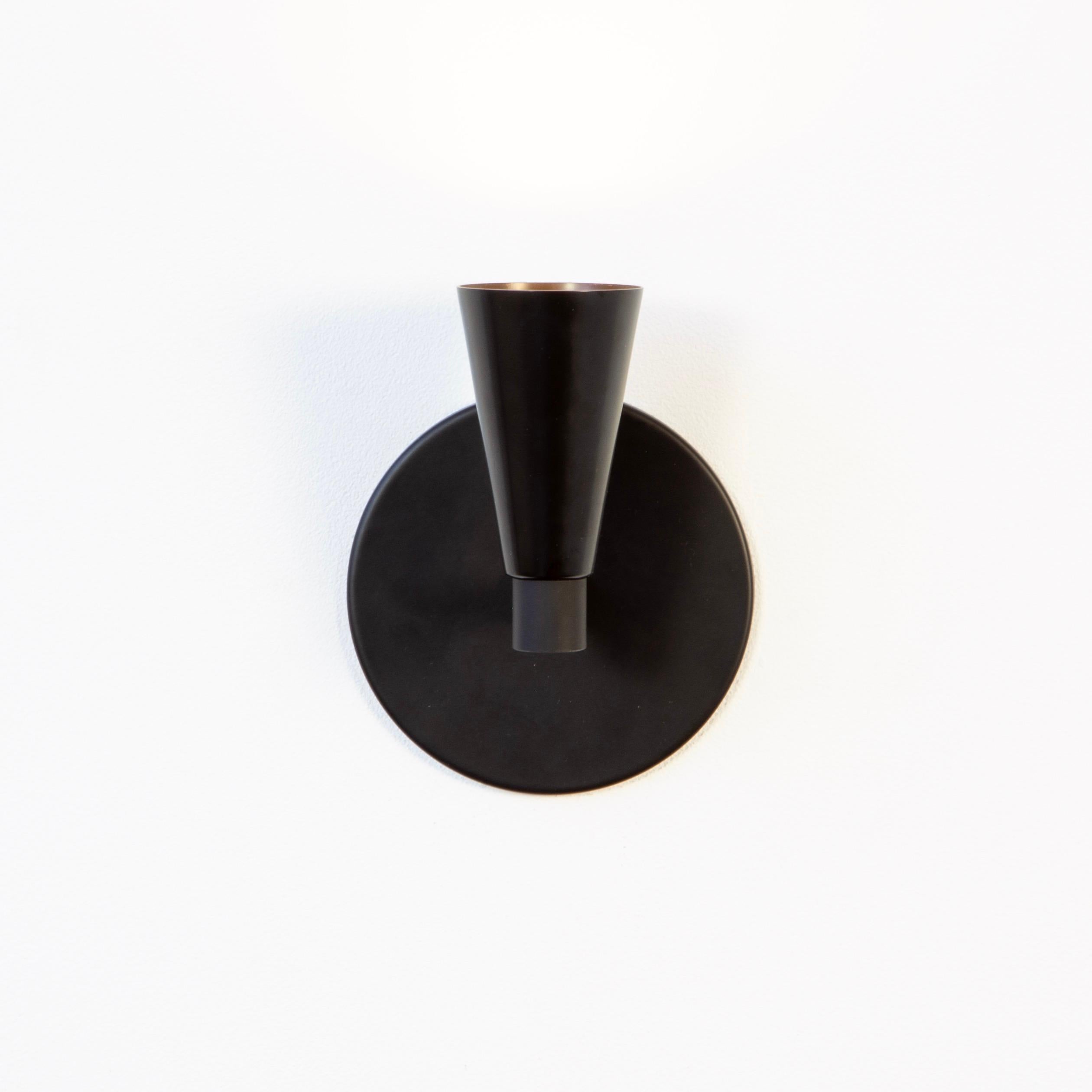This listing is for 1x Cone 1 Sconce in black manufactured by Research.Lighting. It can be used facing up or down.

Materials: Brass, Steel & Glass
Finish: Black
Electronics: 1x G8 Socket, 1x 6 Watt LED Bulb (included), 600 Lumens
UL Listed. Made in