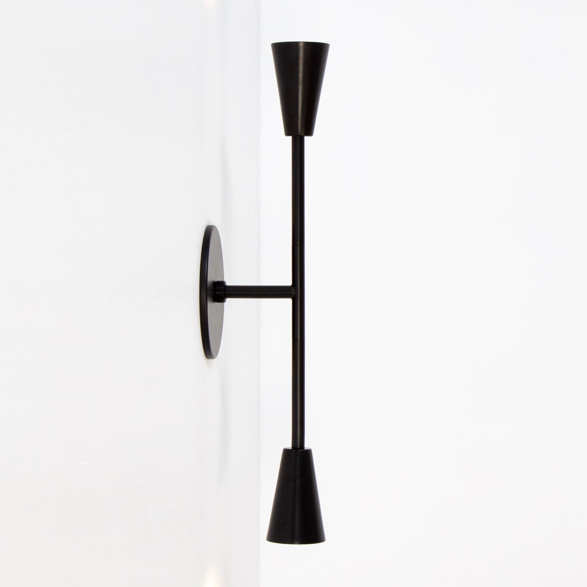 This listing is for 1x Cone 2 Large Sconce designed and manufactured by Research.Lighting. 

Materials: Steel, Brass
Finish: Powder Coated Steel in black
Electronics: 2x G9 Sockets, 2x 4.5 Watt LED Bulbs (included), 900 Lumens total
UL Listed. Made