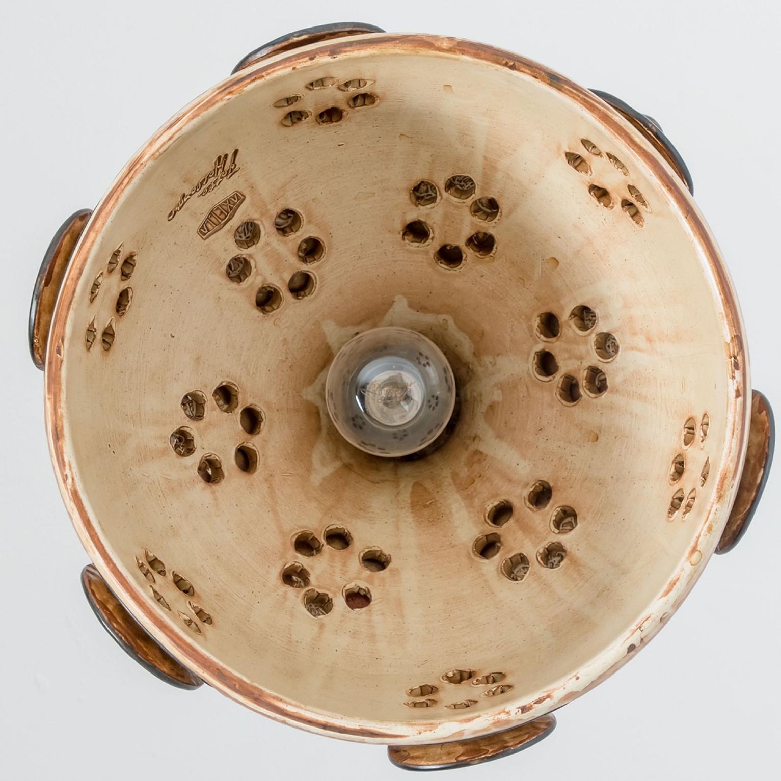 Superbe lampe suspendue ronde de forme inhabituelle, fabriquée dans les années 1970 au Danemark avec des céramiques noires et beiges aux riches couleurs brunes. Nous disposons également d'une multitude de jeux de lumière et d'arrangements uniques en