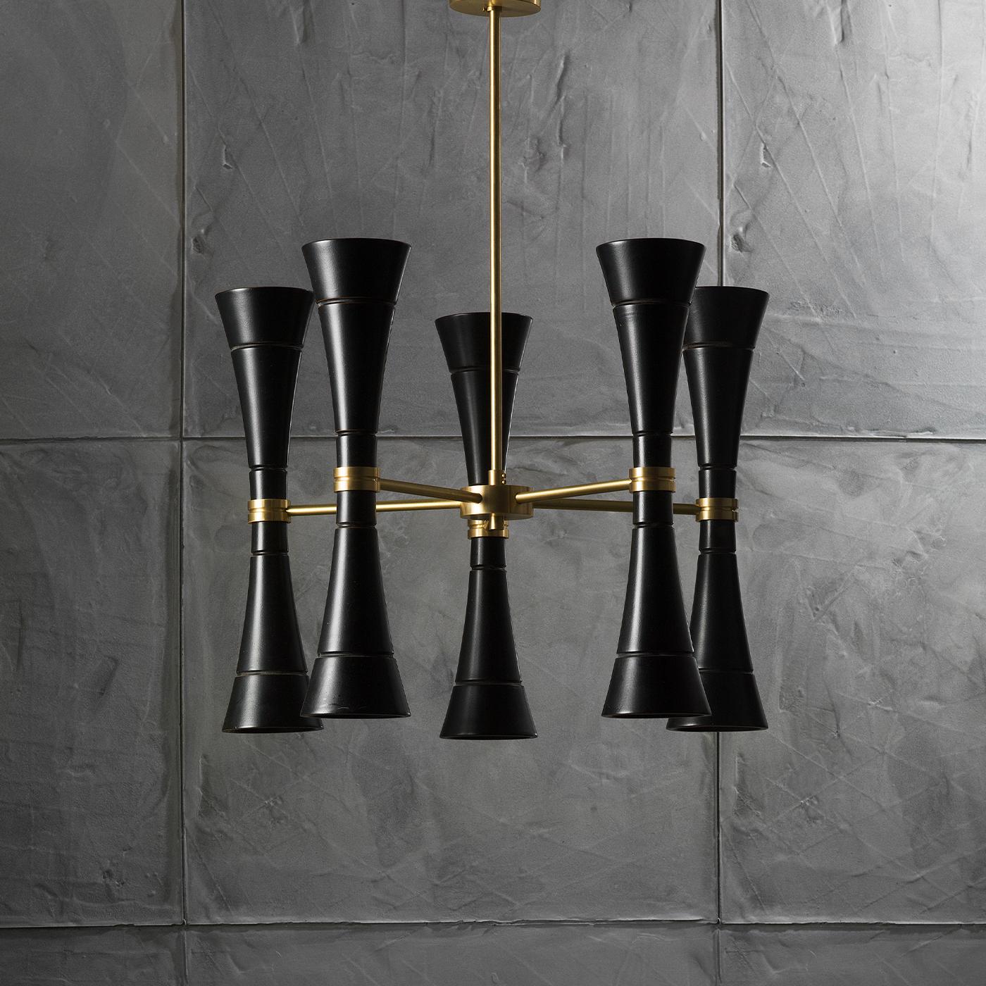 A chandelier with 10 antiqued-black painted wood lights and central structure in satin brass. A LED light is housed at the two ends of each cone-shaped element, so as to project the light both upwards and downwards. Perfect for a place that is in