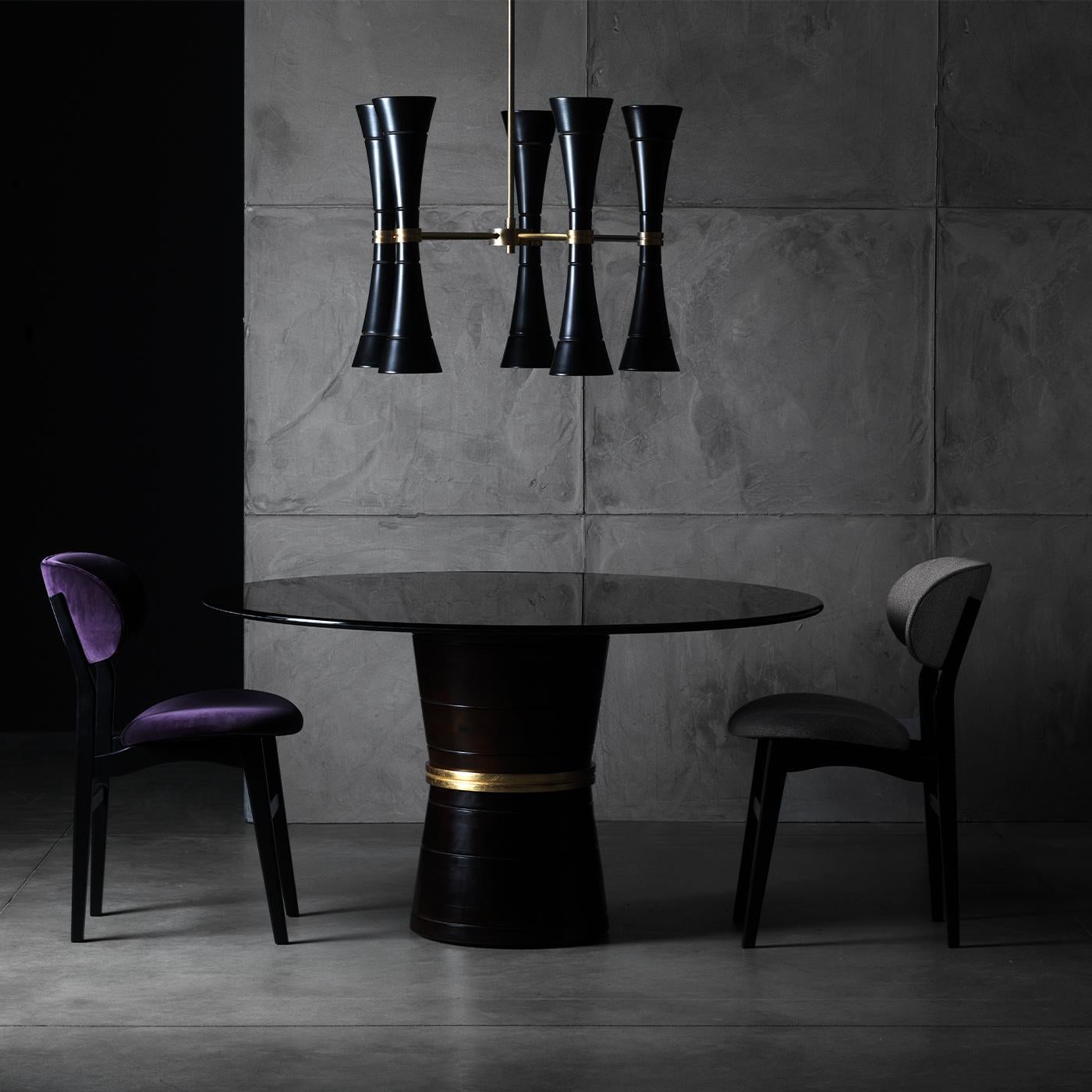 Taking modern styling to new heights, the Cone Dining Table is defined by its unique silhouette. Its bobbin-shaped base is crafted from solid wood with a dark walnut finish, accentuated with a gold metal detail and topped with a smoked tempered