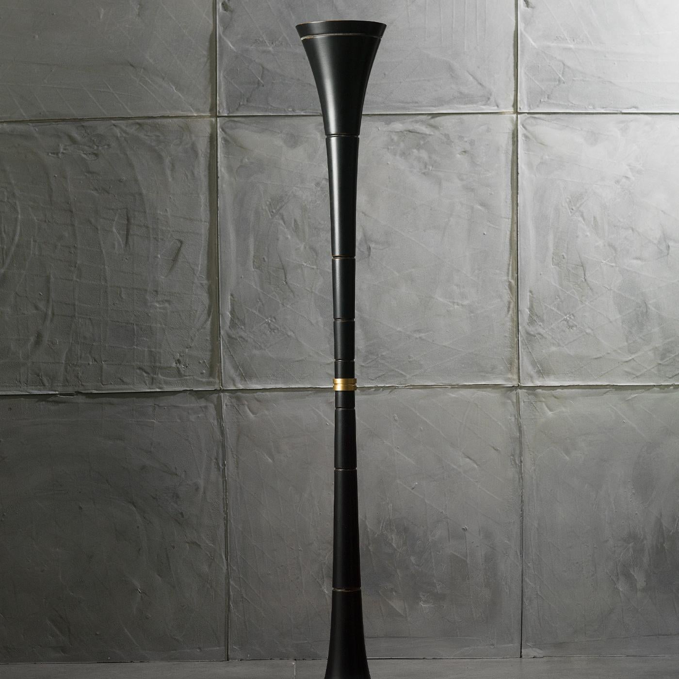 This simple yet classy cone-shaped floor lamp is perfect for every kind of environment and setting. The shape is made in antiqued-black wood and it has an insert in the middle made in satin brass. The light comes evenly out of the cone by using a