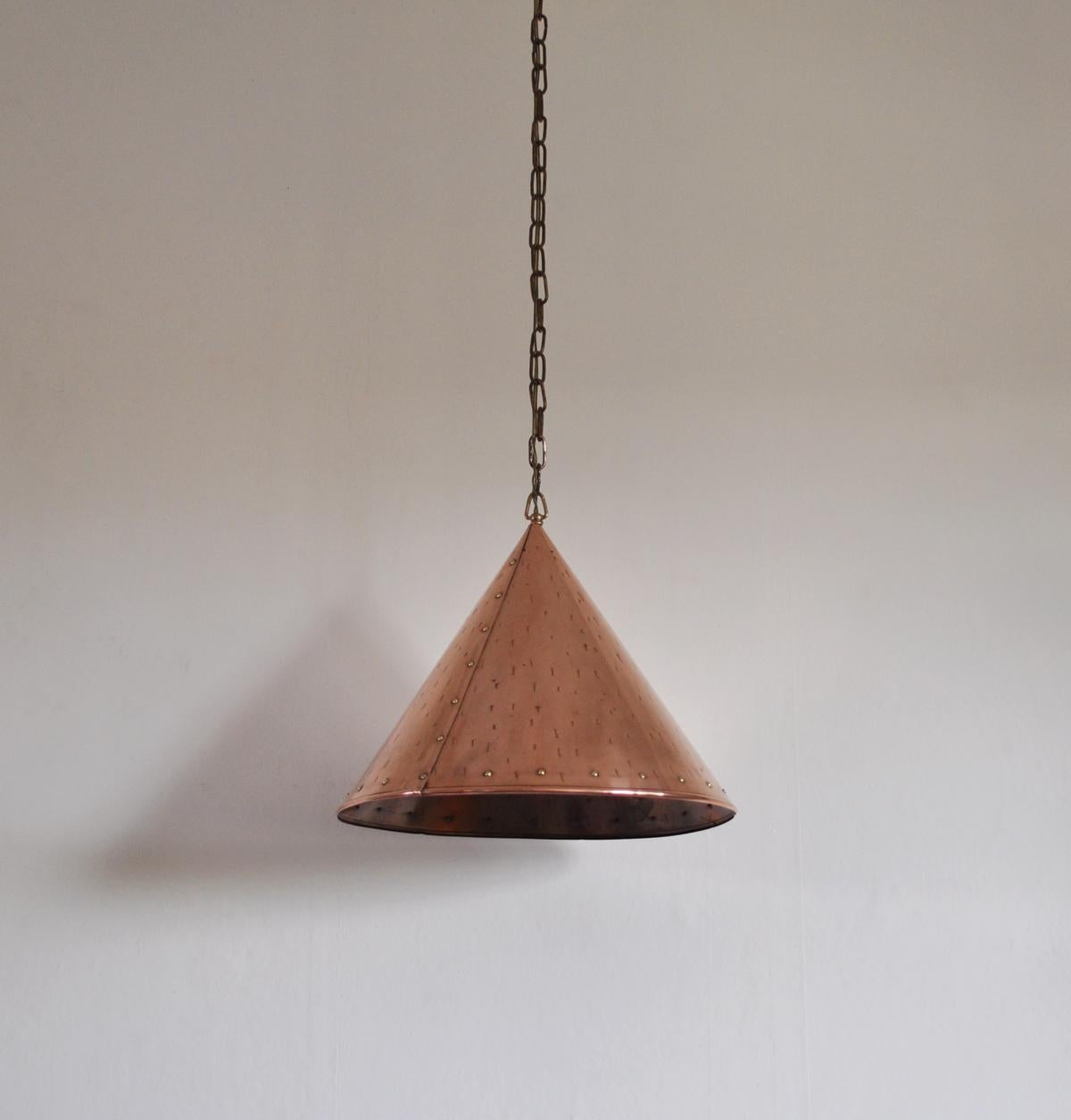 Handcrafted Danish cone shaped copper pendent lamp with beautiful brass details. Made in Denmark in the 1970s.

Signs of wear consistent with age and use.

Measures:
Height 35 cm, diameter 41,5 cm.
Height without chain.