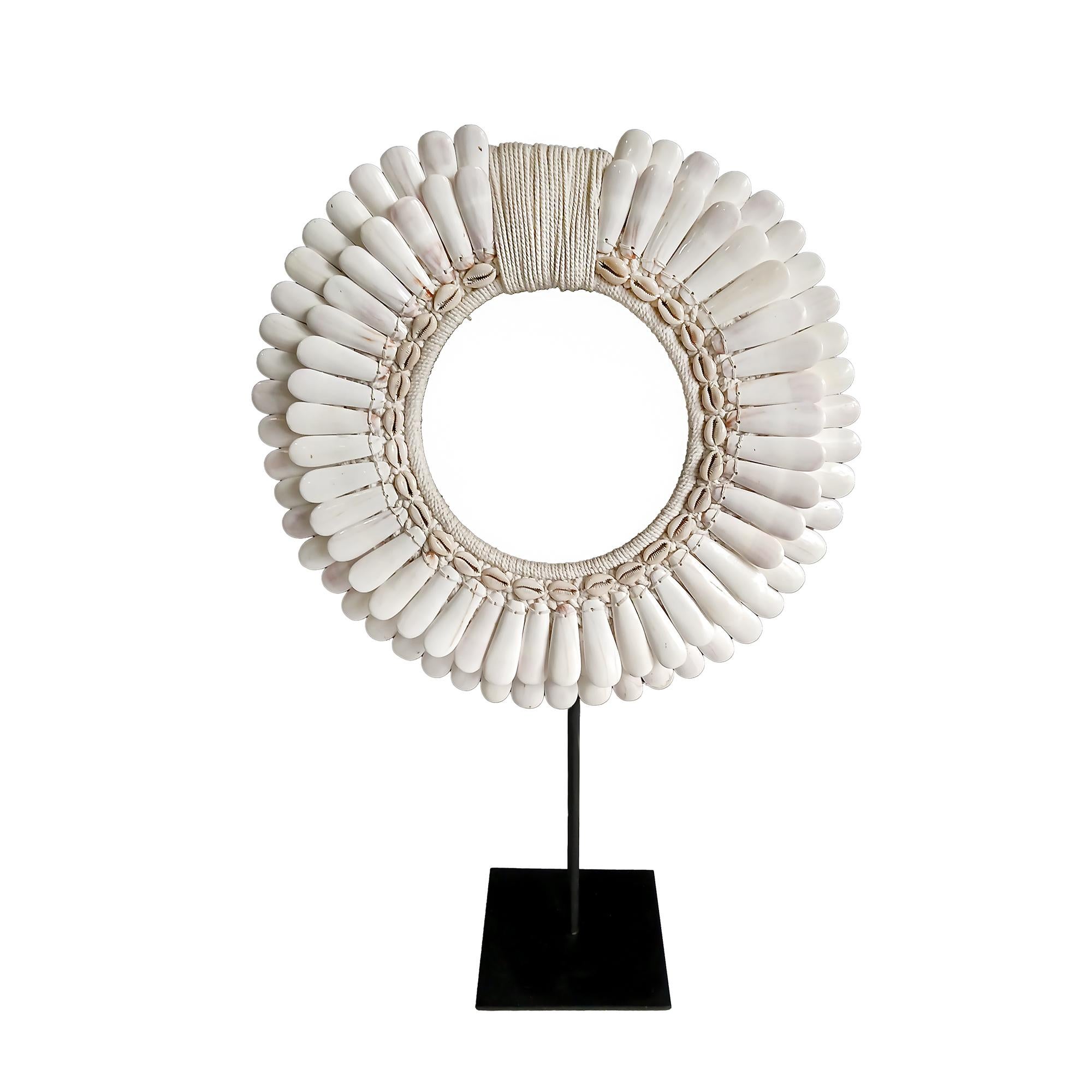 A male necklace from the Asmat Village, Papua New Guinea.

Two rows of large polished shells in concentric rows, seamlessly sewn onto a cotton macramé base, which has been hand-knotted around a semi-circular bamboo frame. Center accents in small